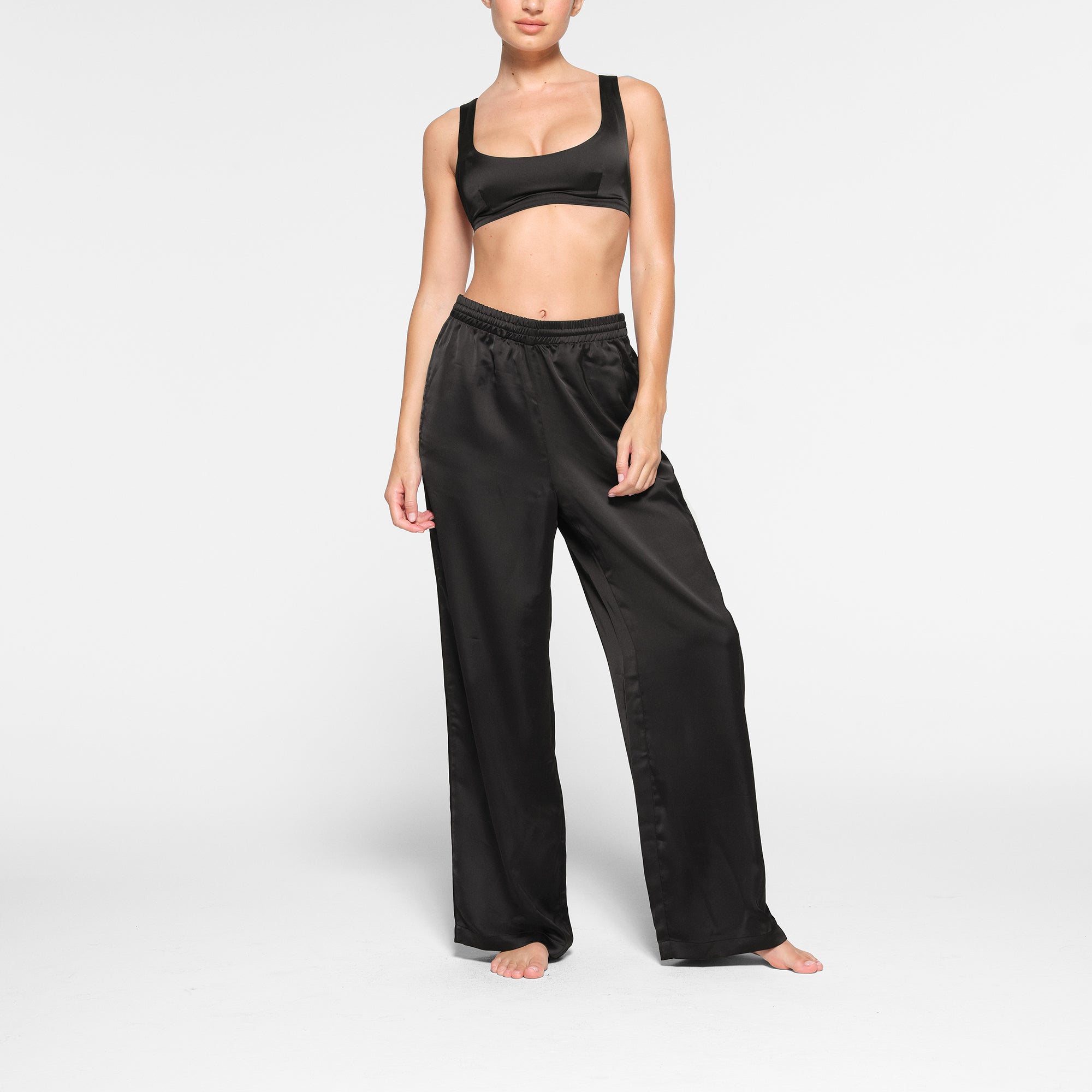 SKIMS SPORTY SATIN STRAIGHT LEG PANT WORN BY A MODEL IN FRONT VIEW