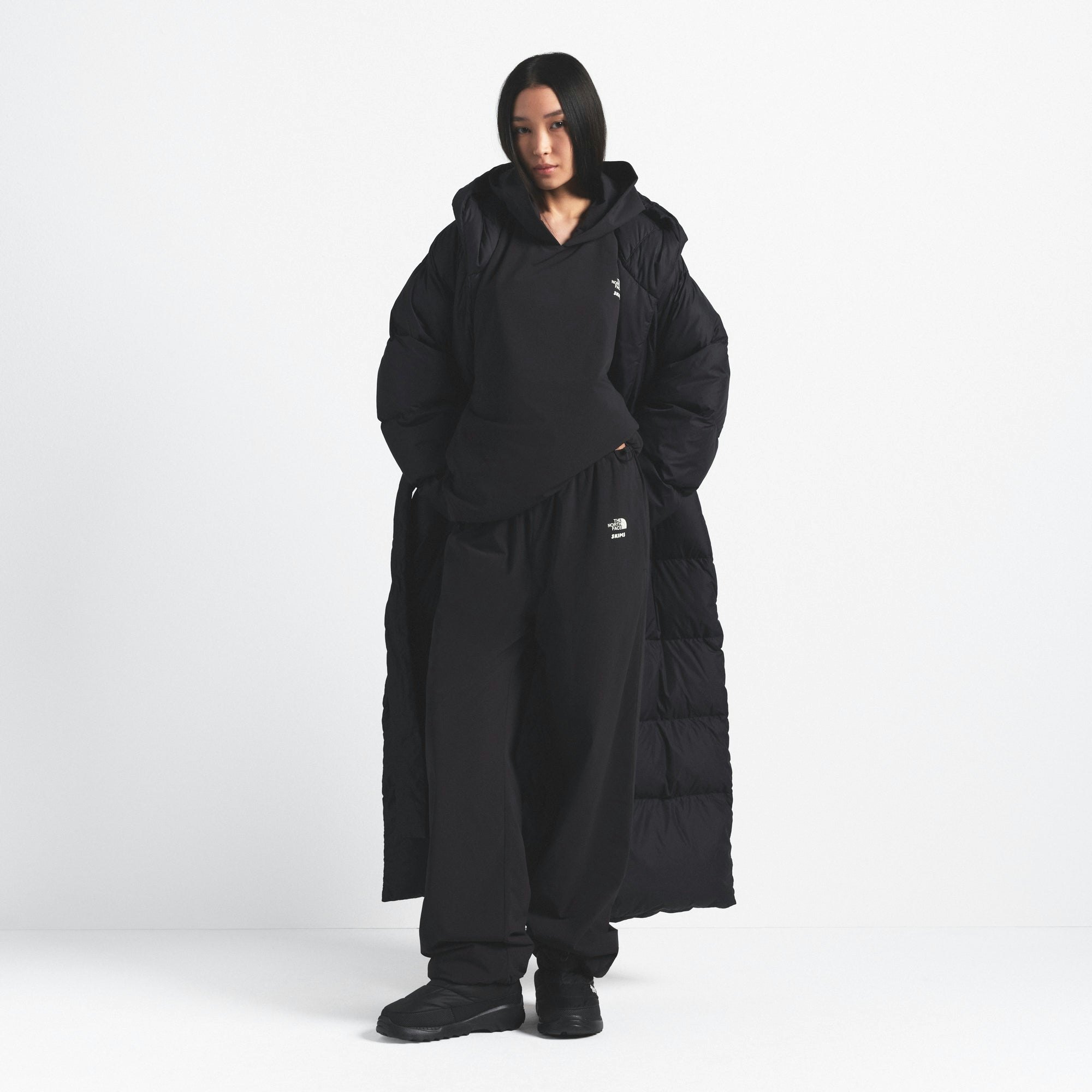 THE NORTH FACE X SKIMS NUPTSE WRAP PARKA | ONYX ON A MODEL FRONT VIEW @ | FOCUS: 0.0, 1.0, 0.9