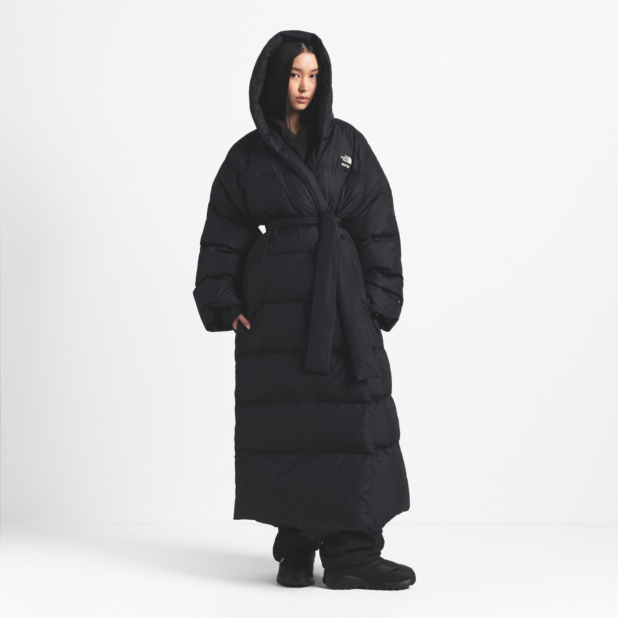 THE NORTH FACE X SKIMS NUPTSE WRAP PARKA | ONYX ON A MODEL FRONT VIEW @ | FOCUS: 0.0, 1.0, 0.9