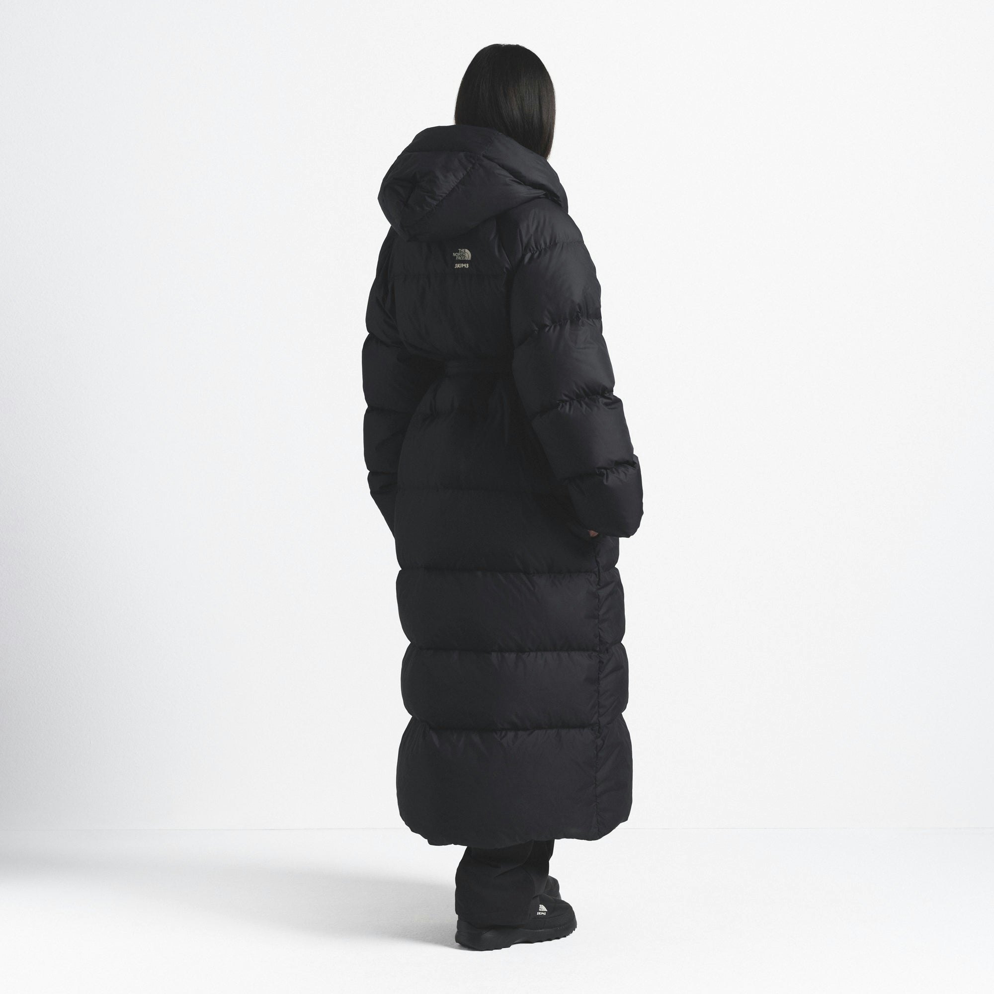 THE NORTH FACE X SKIMS NUPTSE WRAP PARKA | ONYX ON A MODEL FRONT VIEW @ | FOCUS: 0.0, 1.0, 0.9