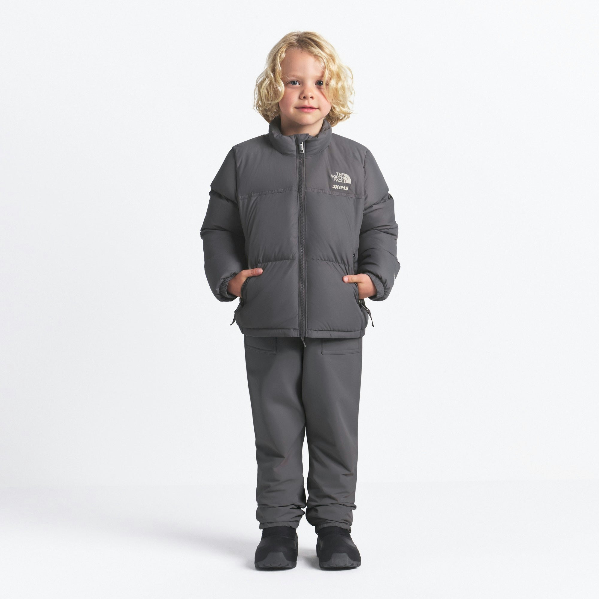 THE NORTH FACE X SKIMS KIDS' 1996 NUPTSE JACKET | GUNMETAL ON A MODEL FRONT VIEW @ | FOCUS: 0.0, 1.0, 0.9