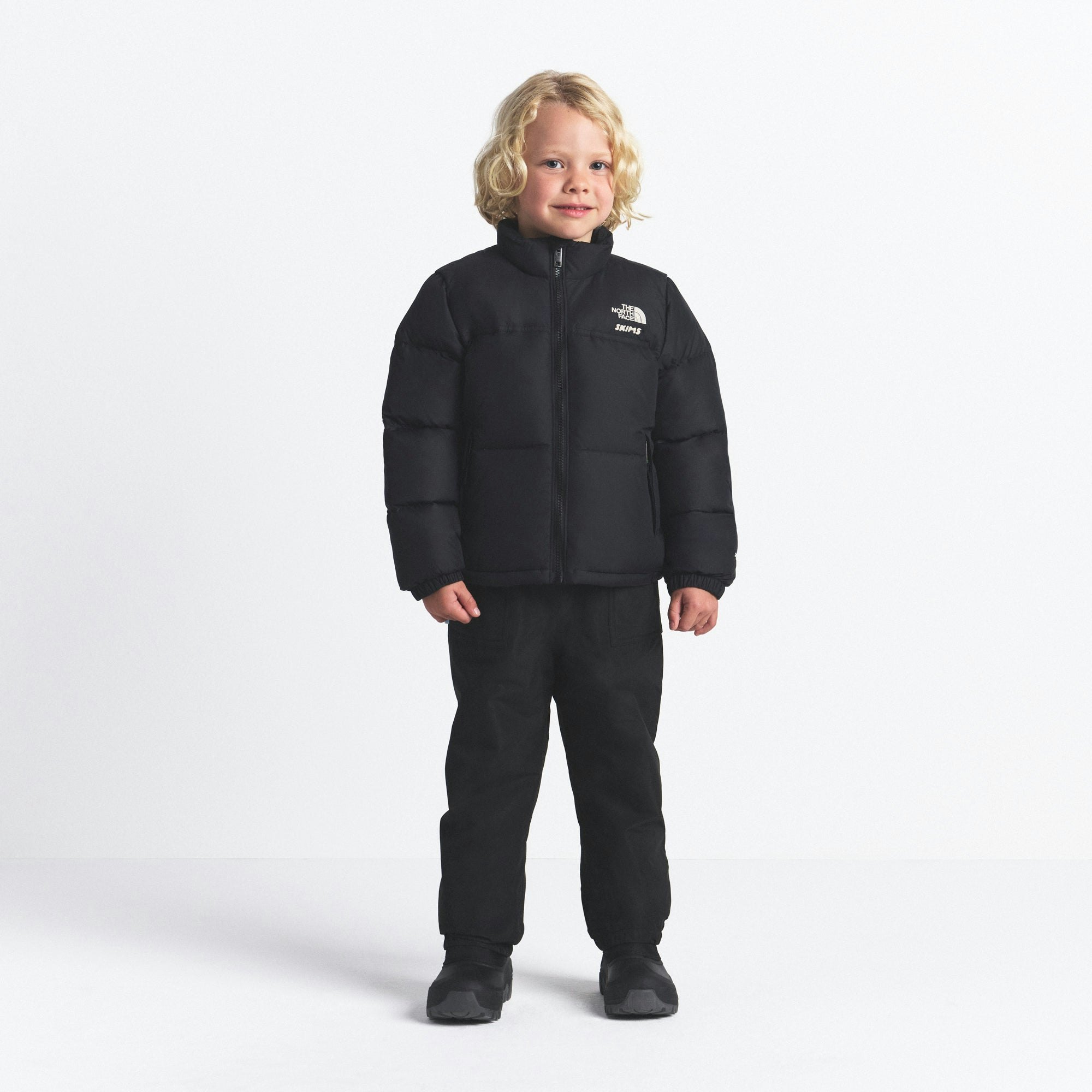 THE NORTH FACE X SKIMS KIDS' 1996 NUPTSE JACKET | ONYX ON A MODEL FRONT VIEW @ | FOCUS: 0.0, 1.0, 0.9
