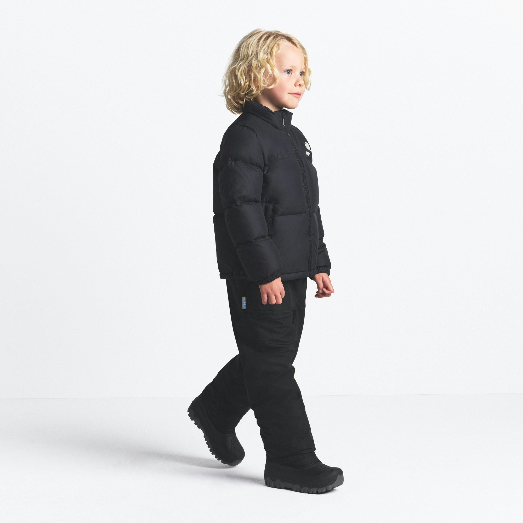 THE NORTH FACE X SKIMS KIDS' 1996 NUPTSE JACKET | ONYX ON A MODEL FRONT VIEW @ | FOCUS: 0.0, 1.0, 0.9