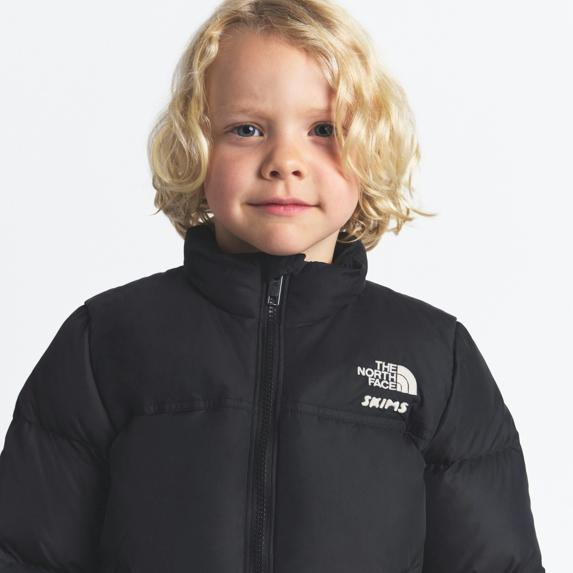 THE NORTH FACE X SKIMS KIDS' 1996 NUPTSE JACKET | ONYX ON A MODEL FRONT VIEW @ | FOCUS: 0.0, 1.0, 0.9