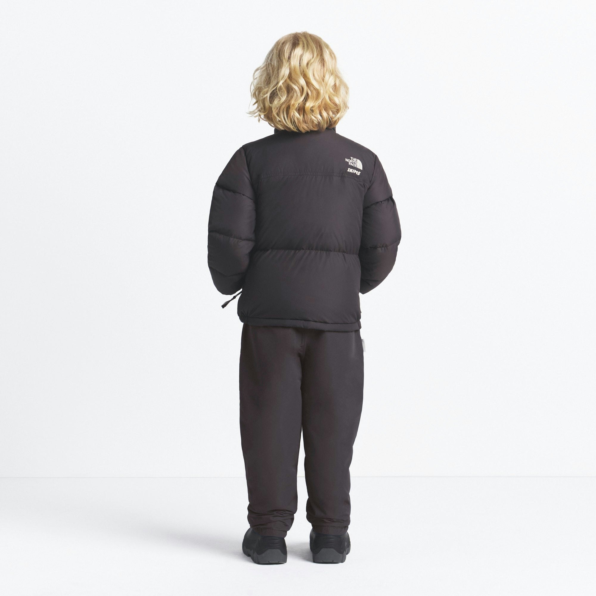 THE NORTH FACE X SKIMS KIDS' 1996 NUPTSE JACKET | PHOENIX ON A MODEL FRONT VIEW @ | FOCUS: 0.0, 1.0, 0.9