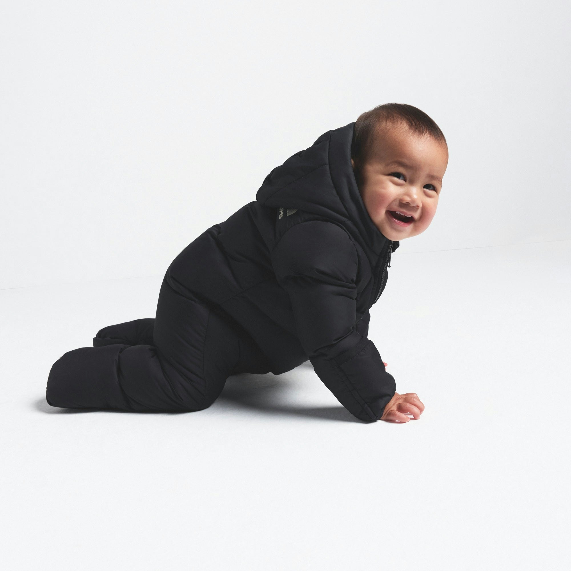 THE NORTH FACE X SKIMS BABY 1996 NUPTSE ONE-PIECE | ONYX ON A MODEL FRONT VIEW @ | FOCUS: 0.0, 1.0, 0.9