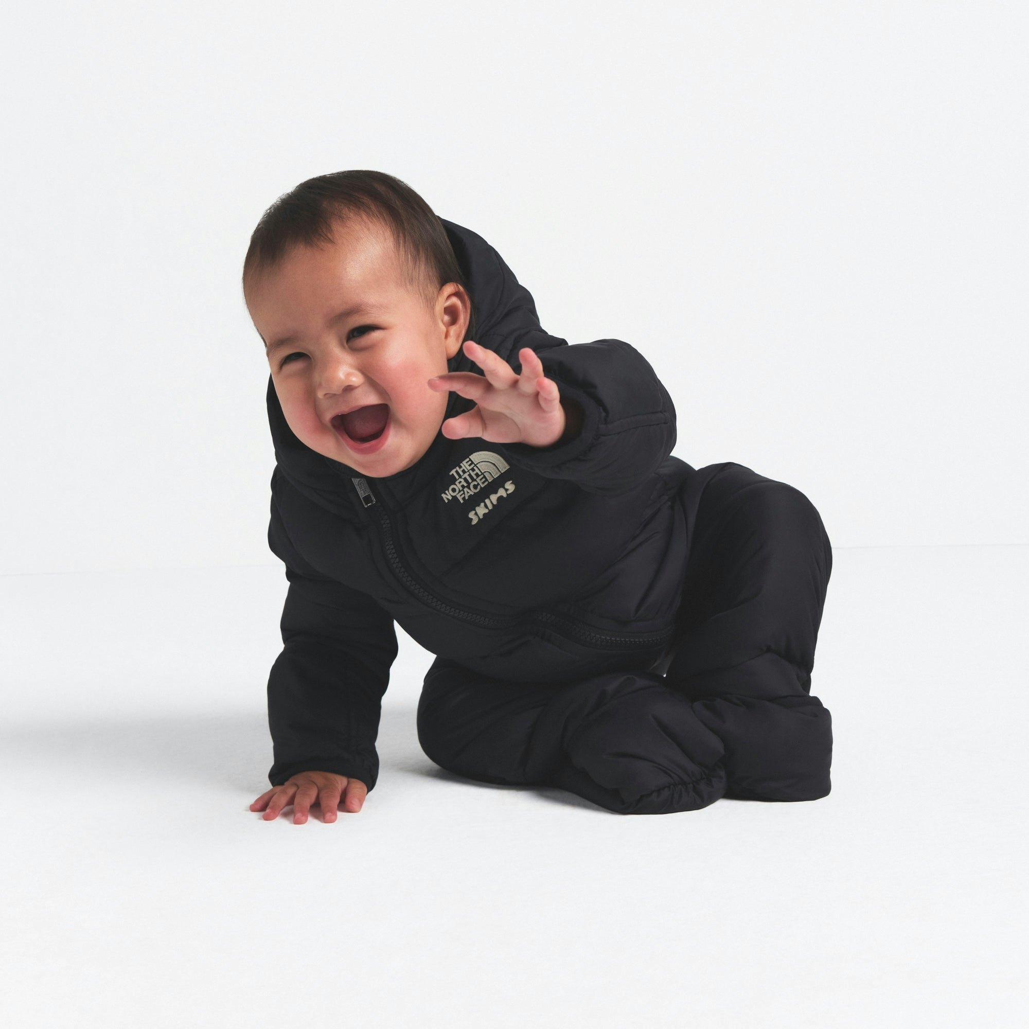 THE NORTH FACE X SKIMS BABY 1996 NUPTSE ONE-PIECE | ONYX ON A MODEL FRONT VIEW @ | FOCUS: 0.0, 1.0, 0.9