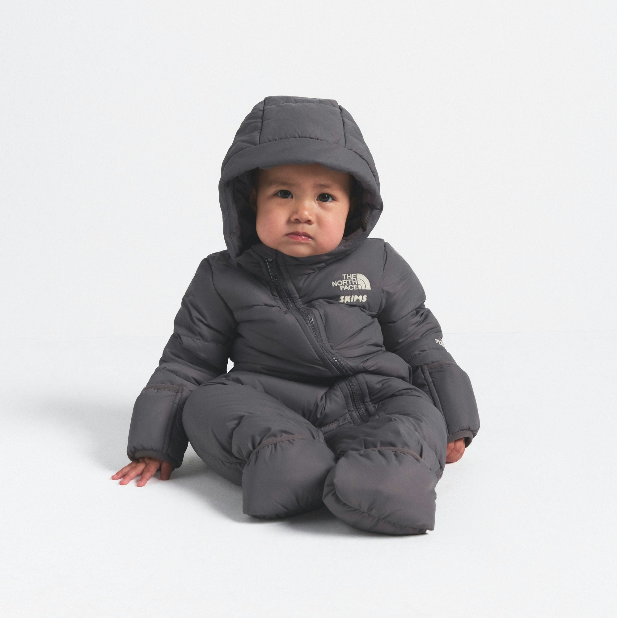 THE NORTH FACE X SKIMS BABY 1996 NUPTSE ONE-PIECE | GUNMETAL ON A MODEL FRONT VIEW @ | FOCUS: 0.0, 1.0, 0.9
