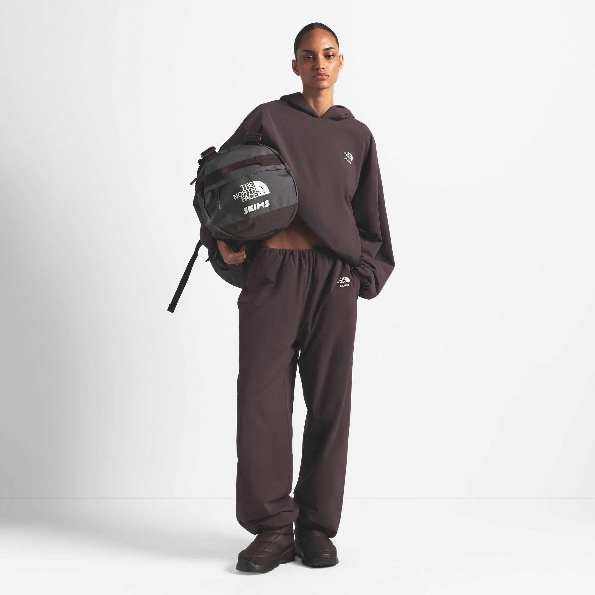 THE NORTH FACE X SKIMS SMALL BASE CAMP DUFFLE BAG | PHOENIX ON A MODEL FRONT VIEW @ | FOCUS: 0.0, 1.0, 0.9