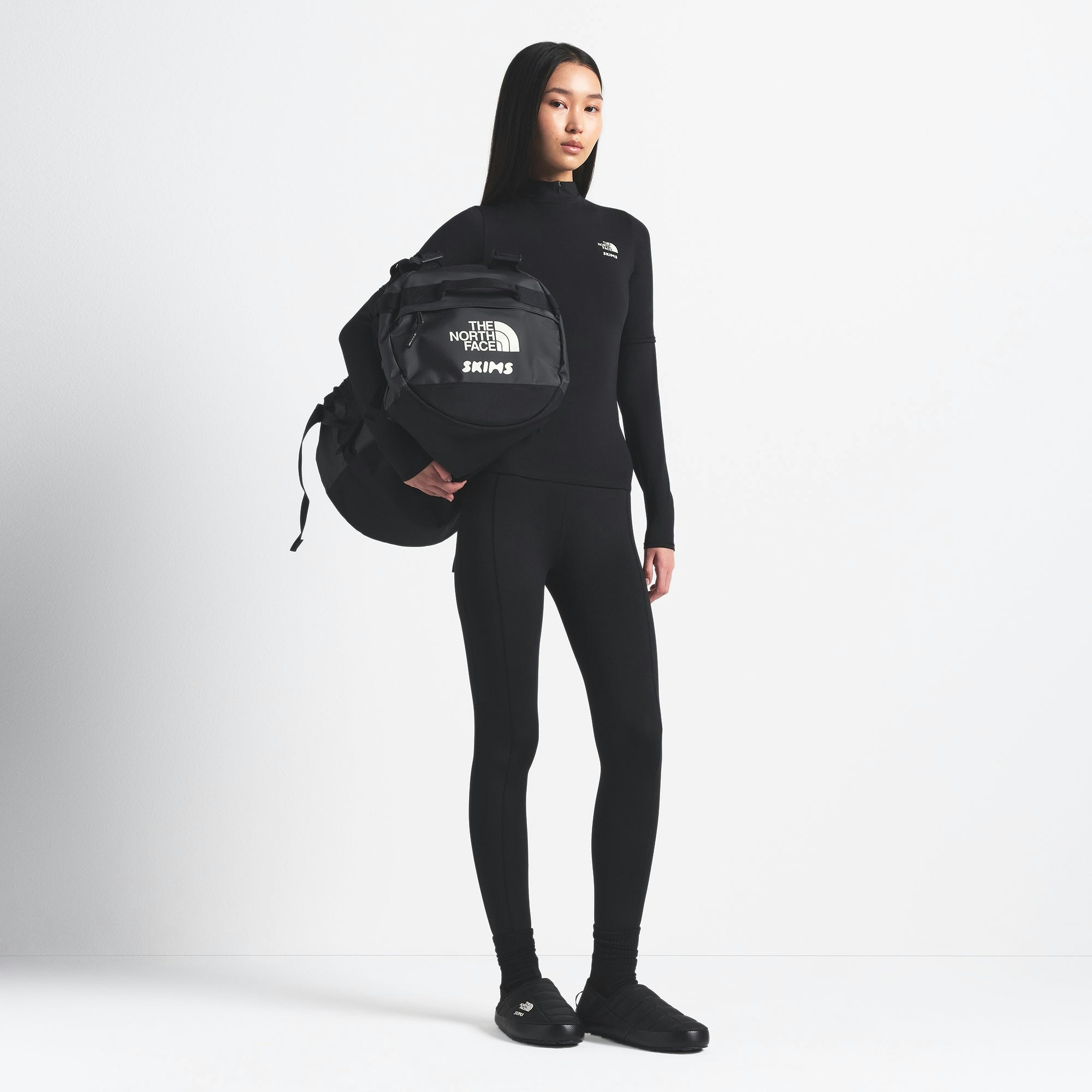 THE NORTH FACE X SKIMS SMALL BASE CAMP DUFFLE BAG | ONYX ON A MODEL FRONT VIEW @ | FOCUS: 0.0, 1.0, 0.9