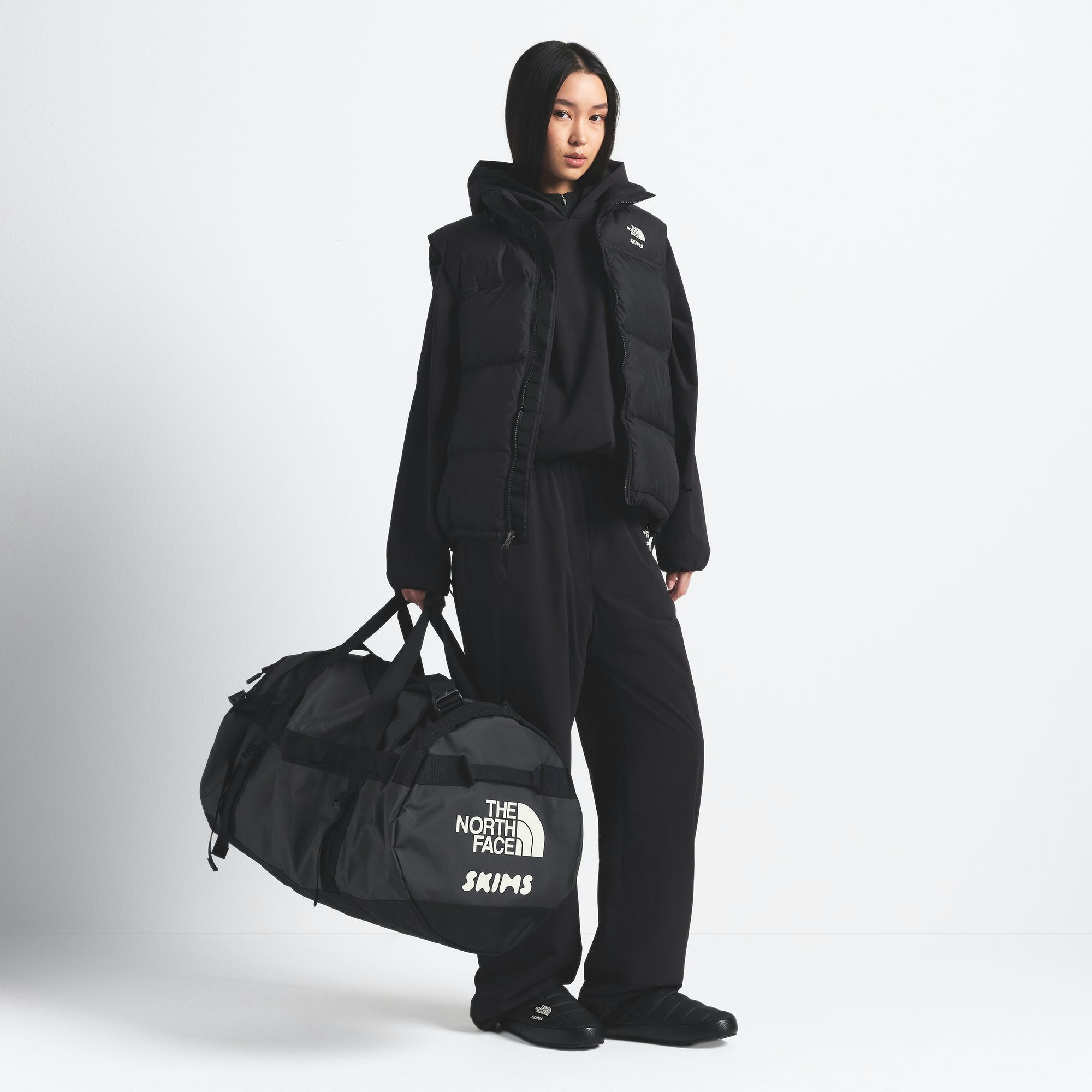 THE NORTH FACE X SKIMS LARGE BASE CAMP DUFFLE BAG | ONYX ON A MODEL FRONT VIEW @ | FOCUS: 0.0, 1.0, 0.9