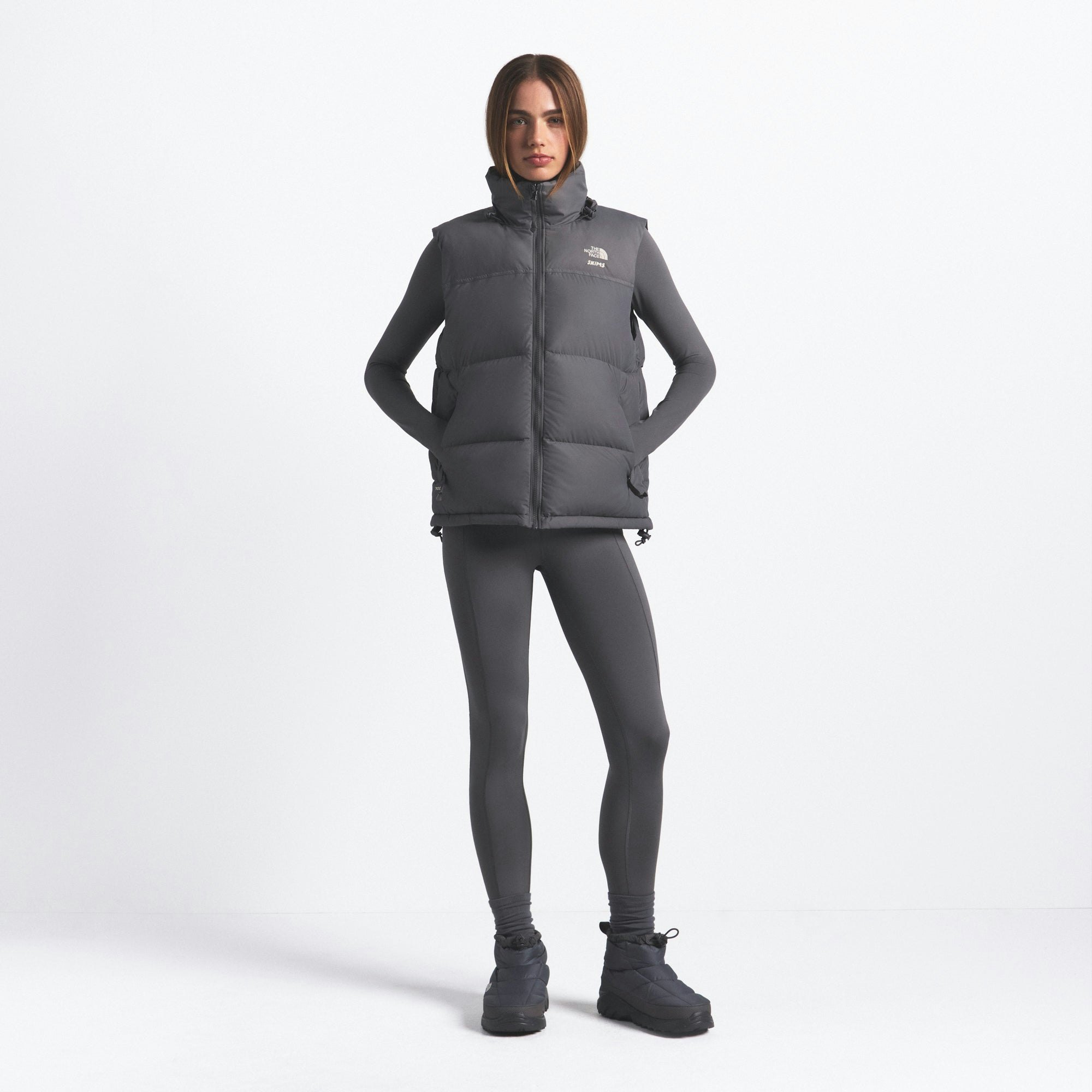 THE NORTH FACE X SKIMS 1996 NUPTSE VEST | GUNMETAL ON A MODEL FRONT VIEW @ | FOCUS: 0.0, 1.0, 0.9