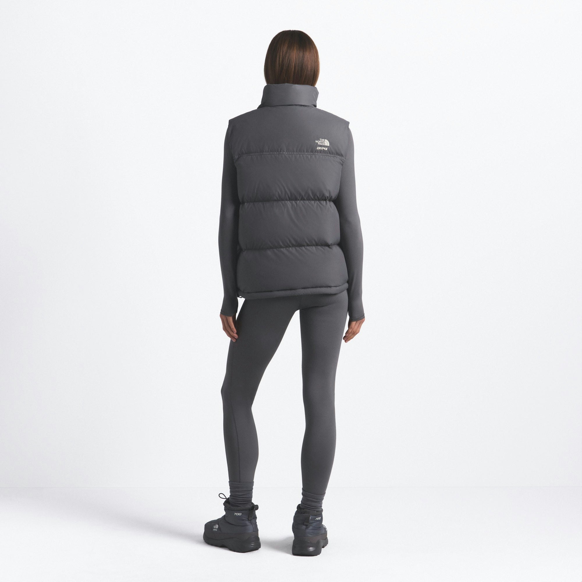THE NORTH FACE X SKIMS 1996 NUPTSE VEST | GUNMETAL ON A MODEL FRONT VIEW @ | FOCUS: 0.0, 1.0, 0.9