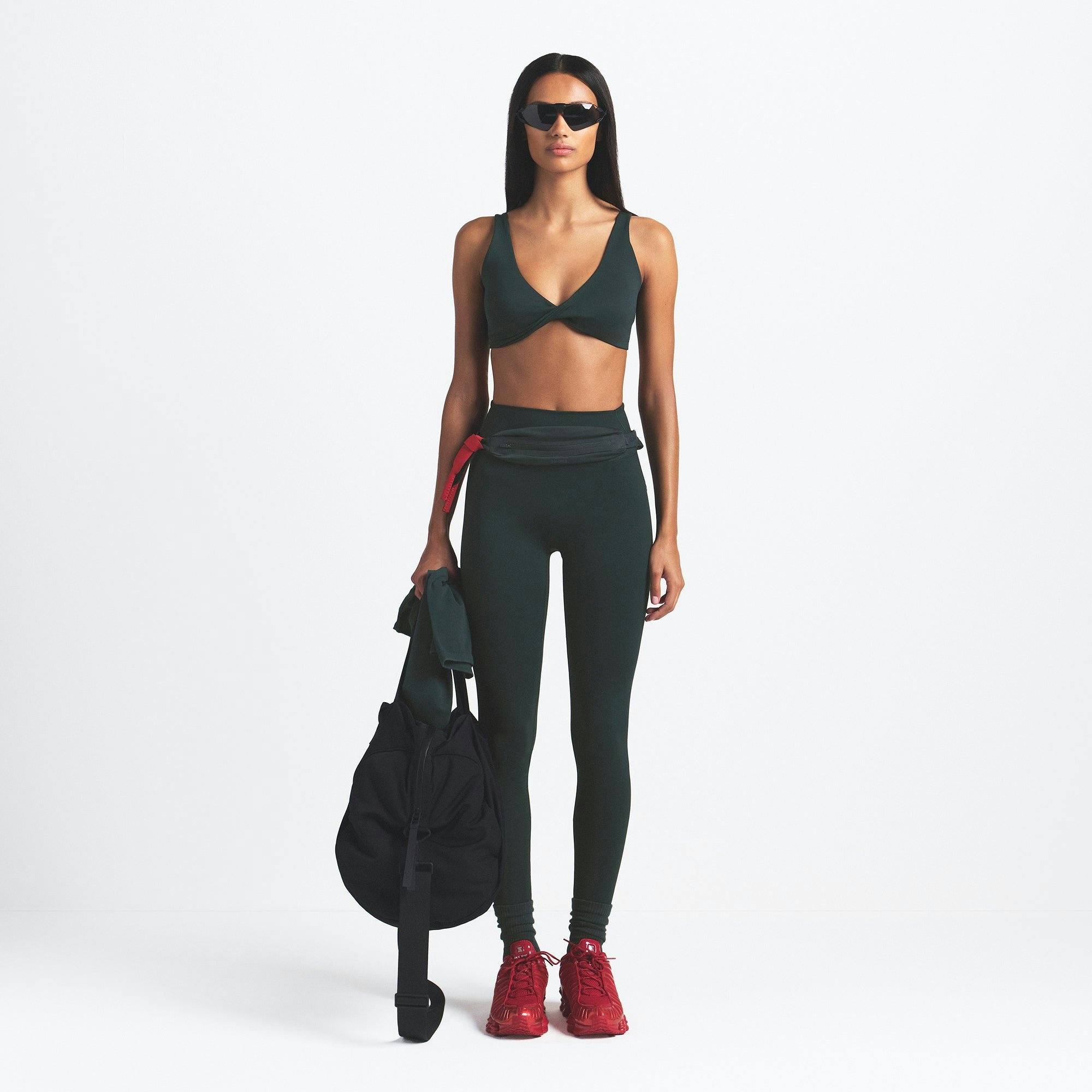 NikeSKIMS MATTE TWIST-FRONT BRA | DARK TEAL ON A MODEL FRONT VIEW @ | FOCUS: 0.0, 1.0, 0.9