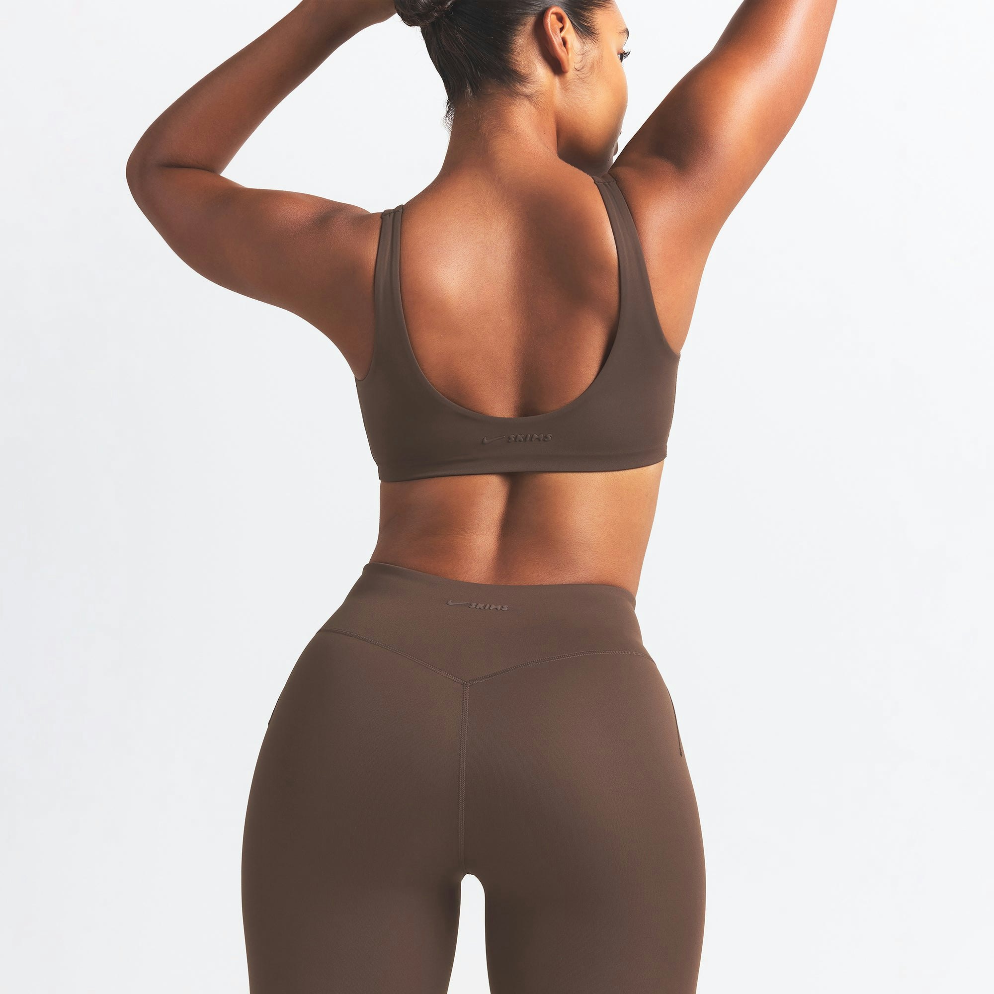 NikeSKIMS MATTE TWIST-FRONT BRA | DARK SEPIA ON A MODEL BACK VIEW @ | FOCUS: 0.0, 1.0, 0.9