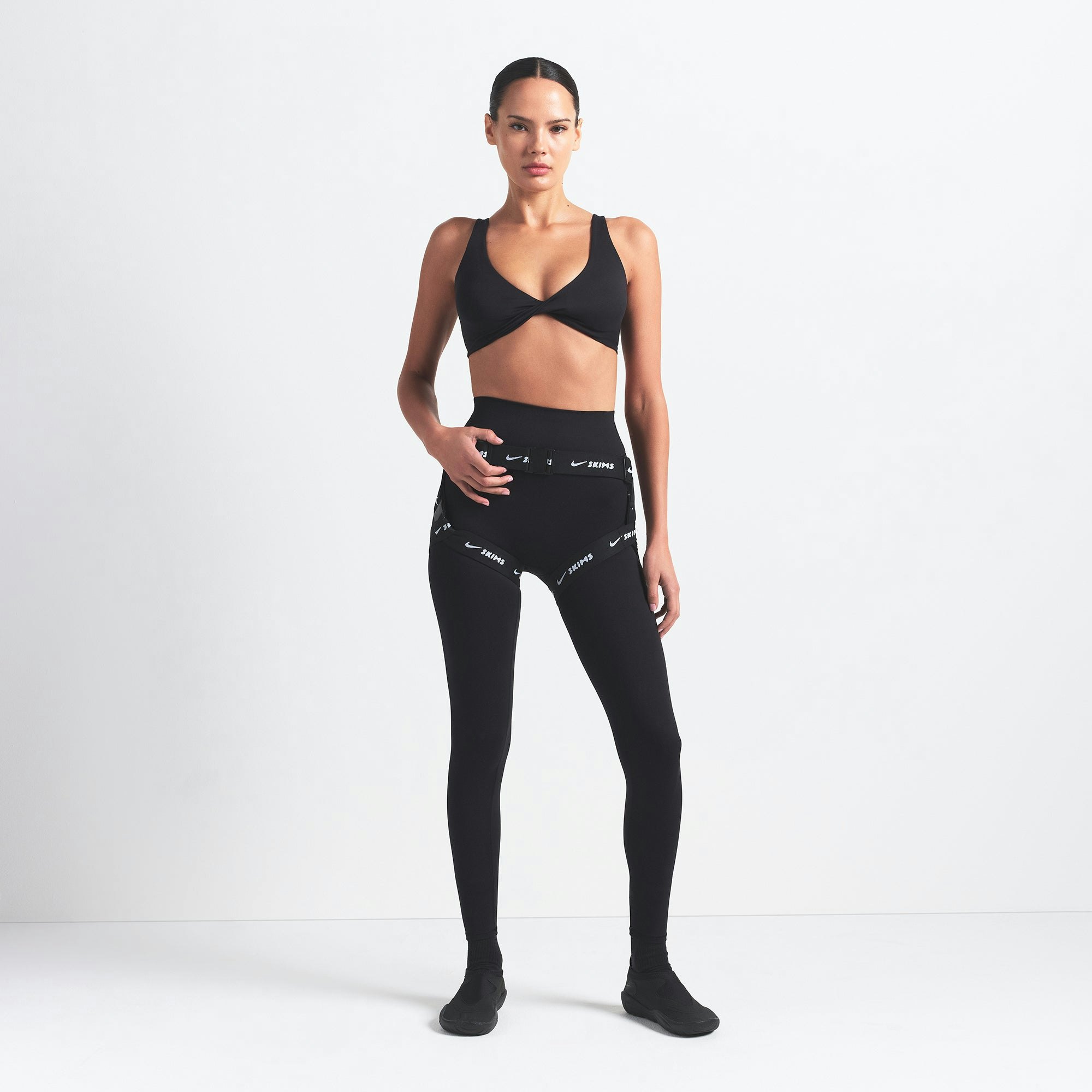 NikeSKIMS MATTE TWIST-FRONT BRA | OBSIDIAN ON A MODEL FRONT VIEW @ | FOCUS: 0.0, 1.0, 0.9