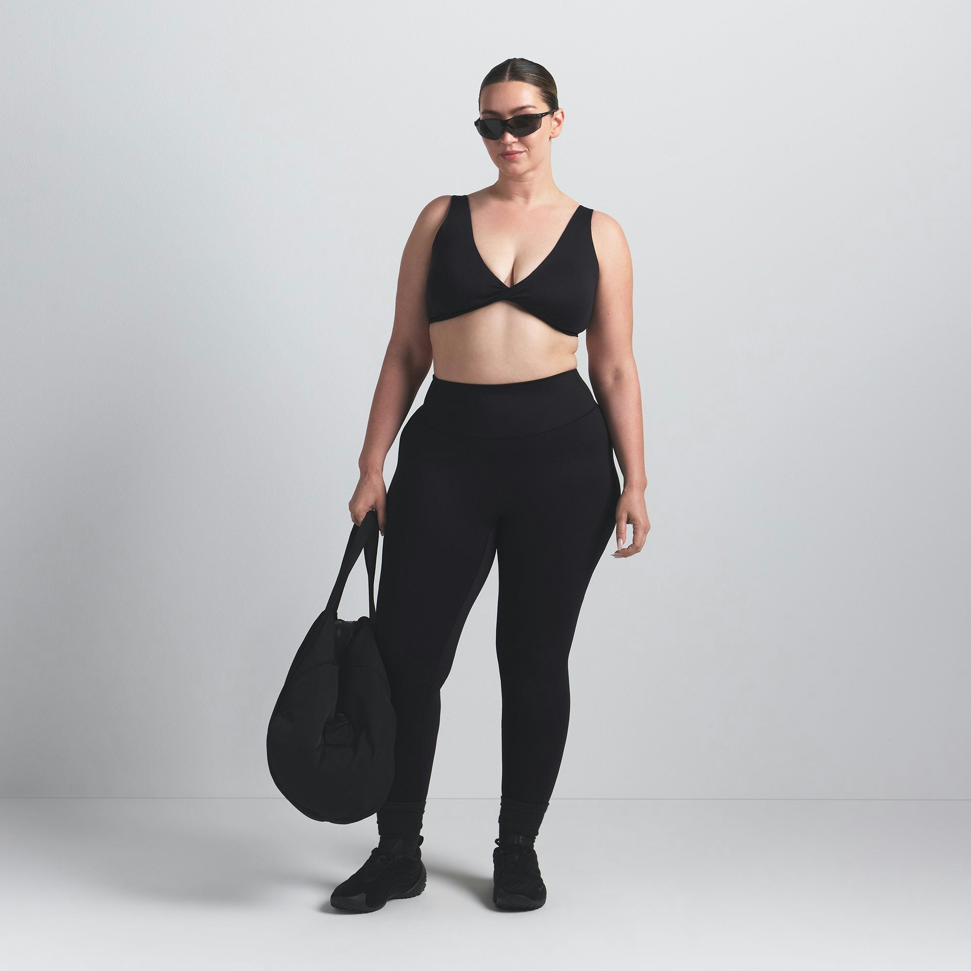 NikeSKIMS MATTE TWIST-FRONT BRA | OBSIDIAN ON A MODEL FRONT VIEW @ | FOCUS: 0.0, 1.0, 0.9