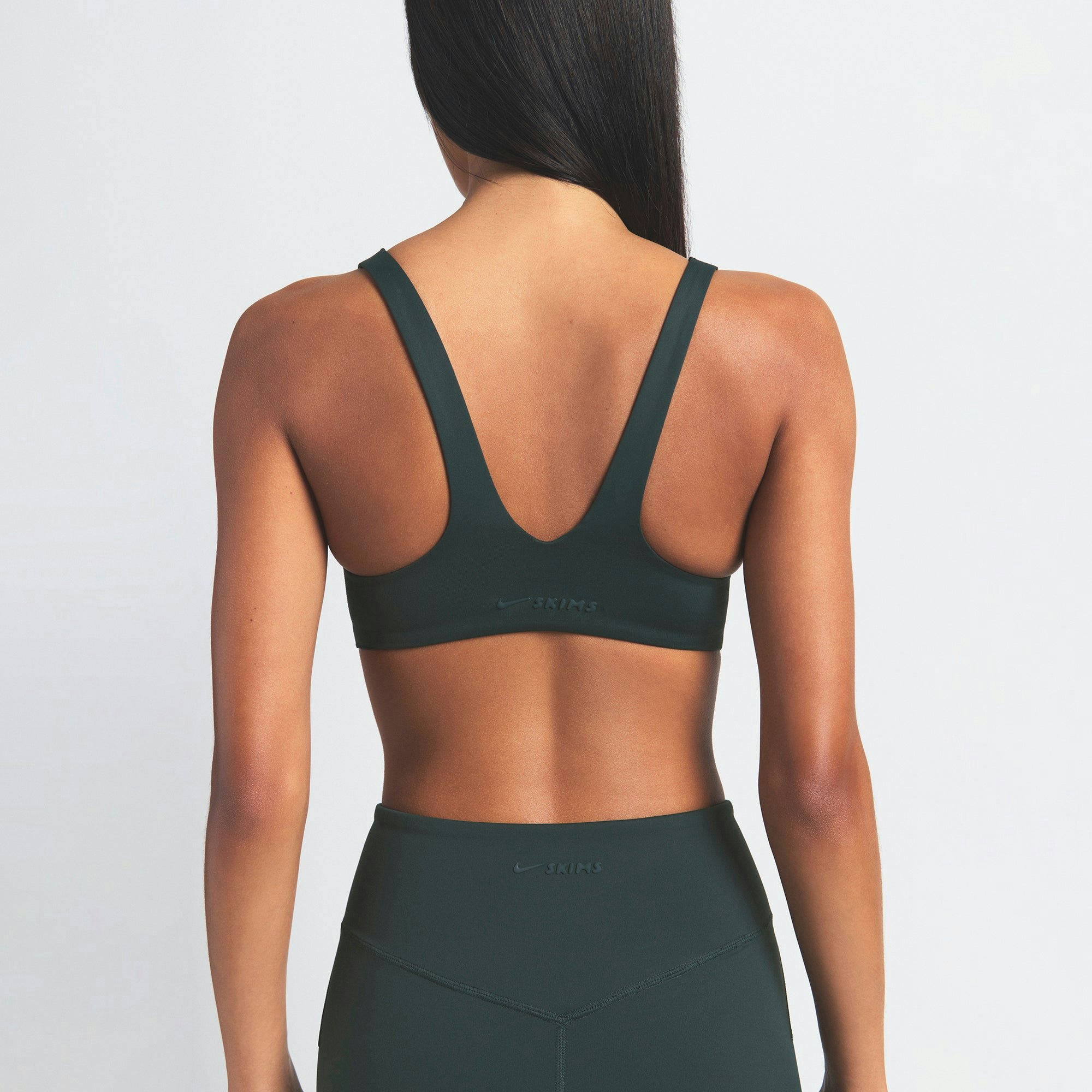 NikeSKIMS MATTE SHAPING SCOOP BRA | DARK TEAL ON A MODEL SIDE VIEW @ | FOCUS: 0.0, 1.0, 0.9