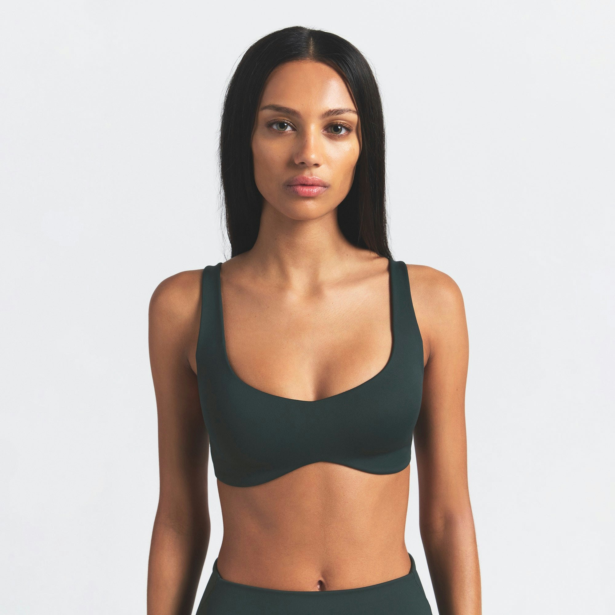 NikeSKIMS MATTE SHAPING SCOOP BRA | DARK TEAL ON A MODEL SIDE VIEW @ | FOCUS: 0.0, 1.0, 0.9