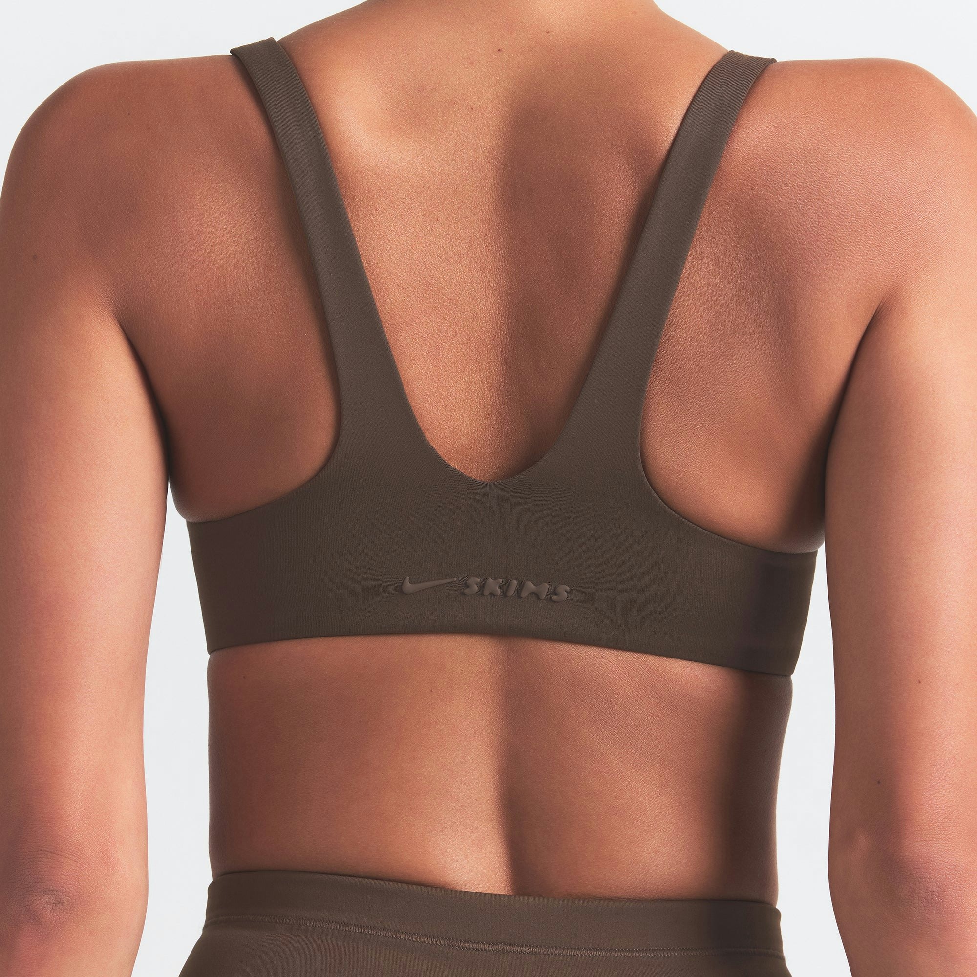 NikeSKIMS MATTE SHAPING SCOOP BRA | DARK SEPIA ON A MODEL BACK VIEW @ | FOCUS: 0.0, 1.0, 0.9