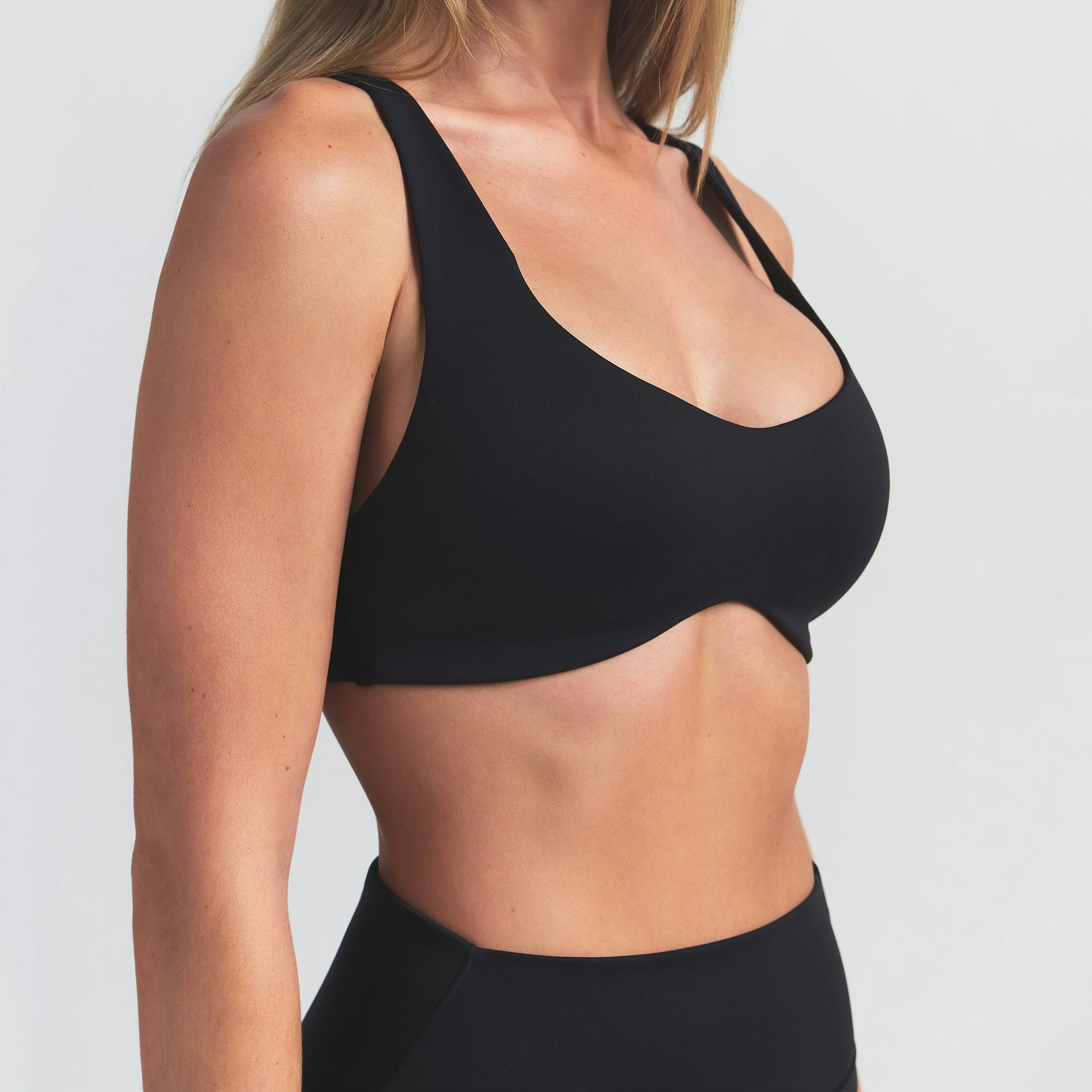 NikeSKIMS MATTE SHAPING SCOOP BRA | OBSIDIAN ON A MODEL SIDE VIEW @ | FOCUS: 0.0, 1.0, 0.9