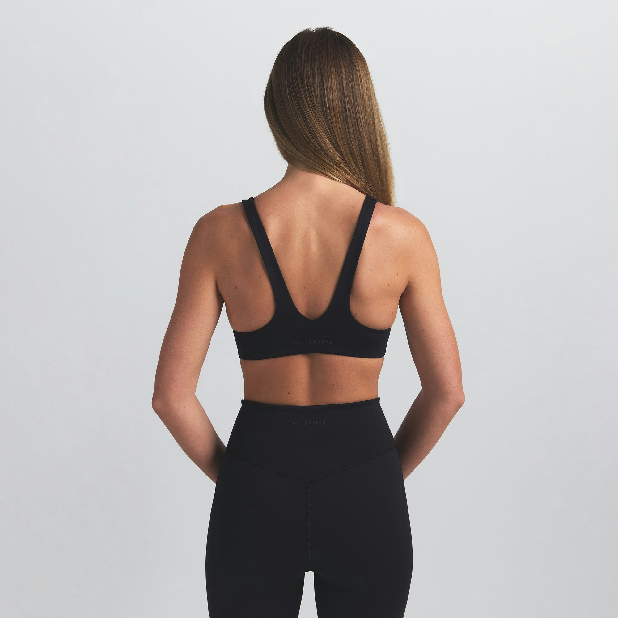 NikeSKIMS MATTE SHAPING SCOOP BRA | OBSIDIAN ON A MODEL BACK VIEW @ | FOCUS: 0.0, 1.0, 0.9