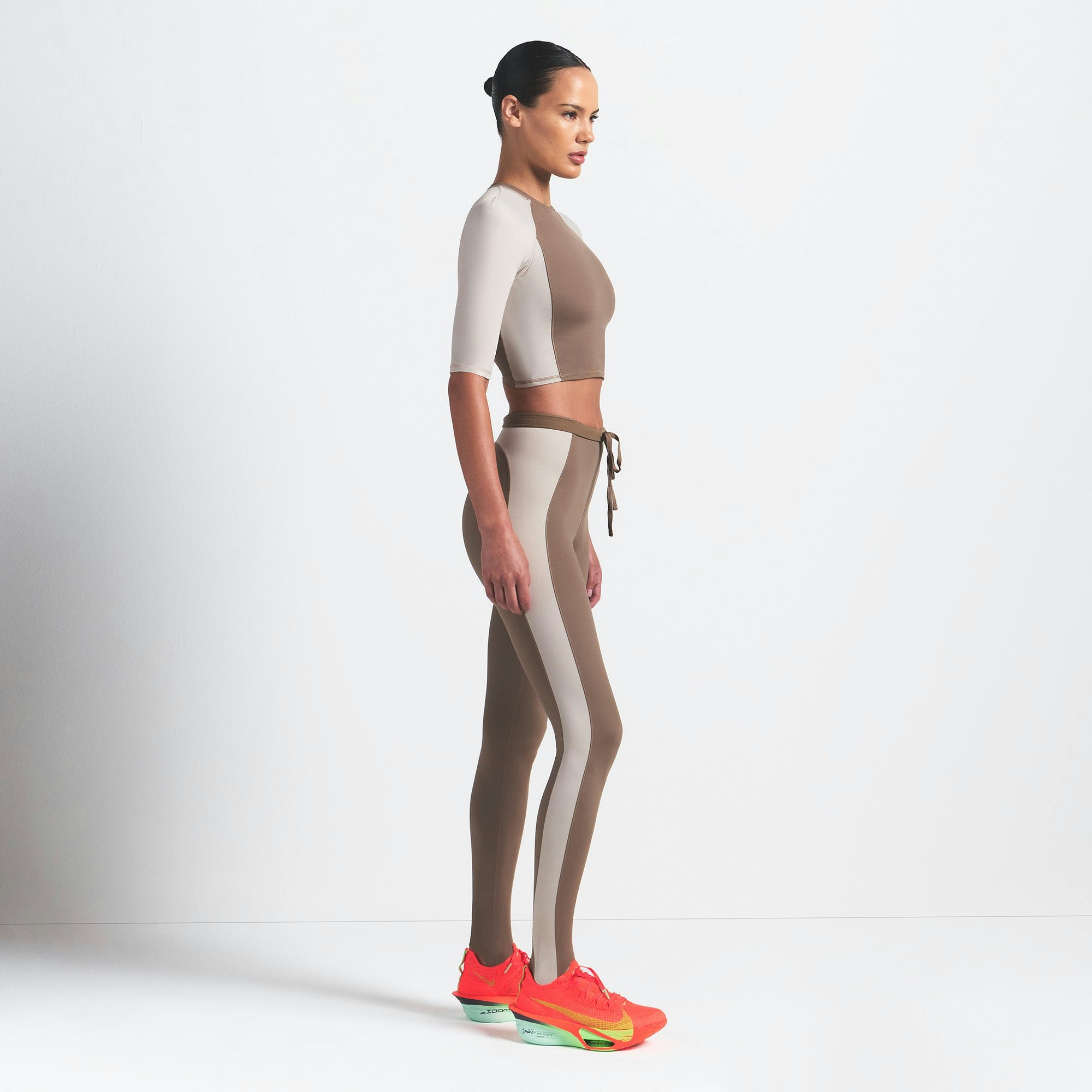 NikeSKIMS SHINE PADDED HALF SLEEVE CROP TOP | TRUFFLE AND STONE ON A MODEL SIDE VIEW @ | FOCUS: 0.0, 1.0, 0.9