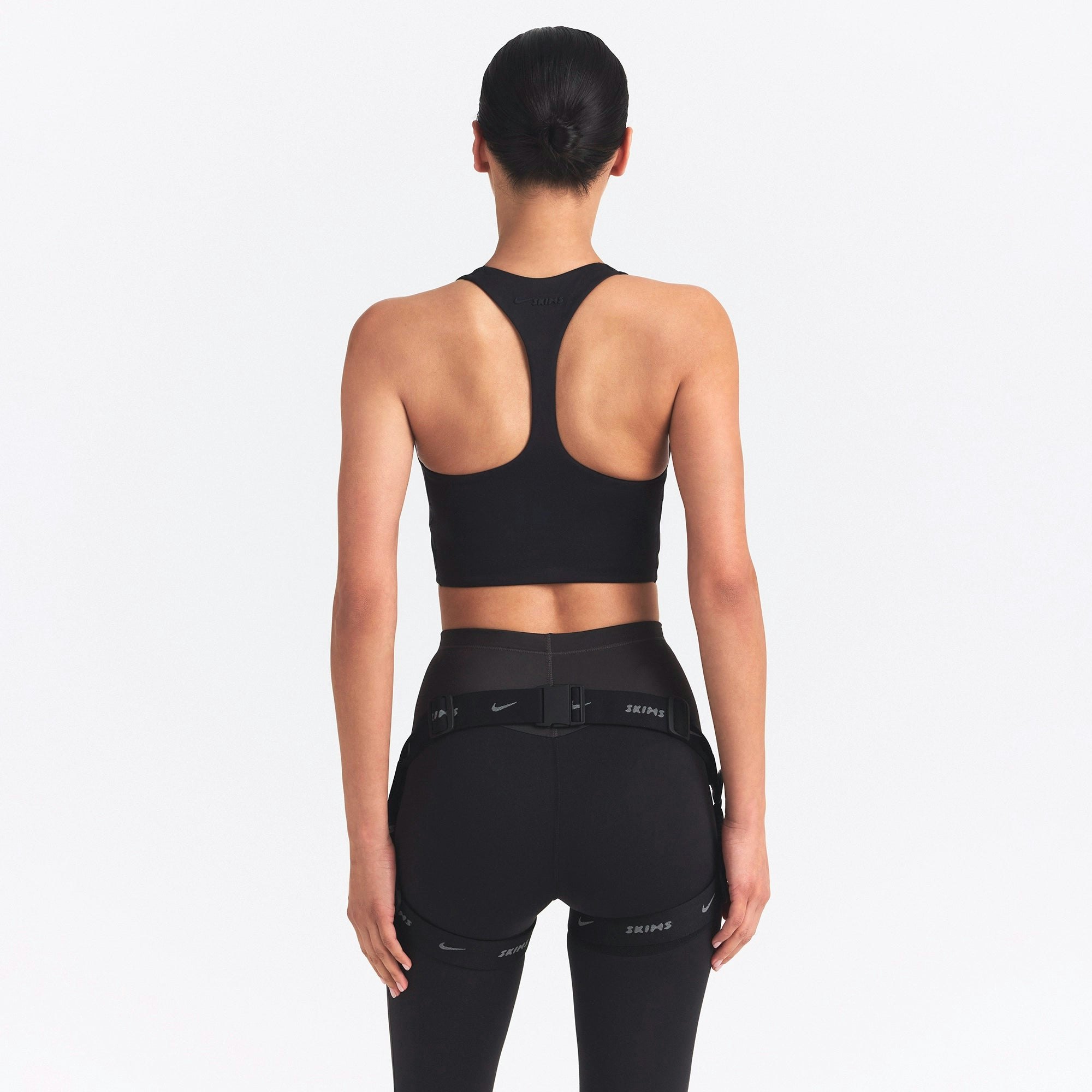 NikeSKIMS MATTE AND SHINE RACERBACK LONGLINE BRA | OBSIDIAN/IGNEOUS ON A MODEL SIDE VIEW @ | FOCUS: 0.0, 1.0, 0.9