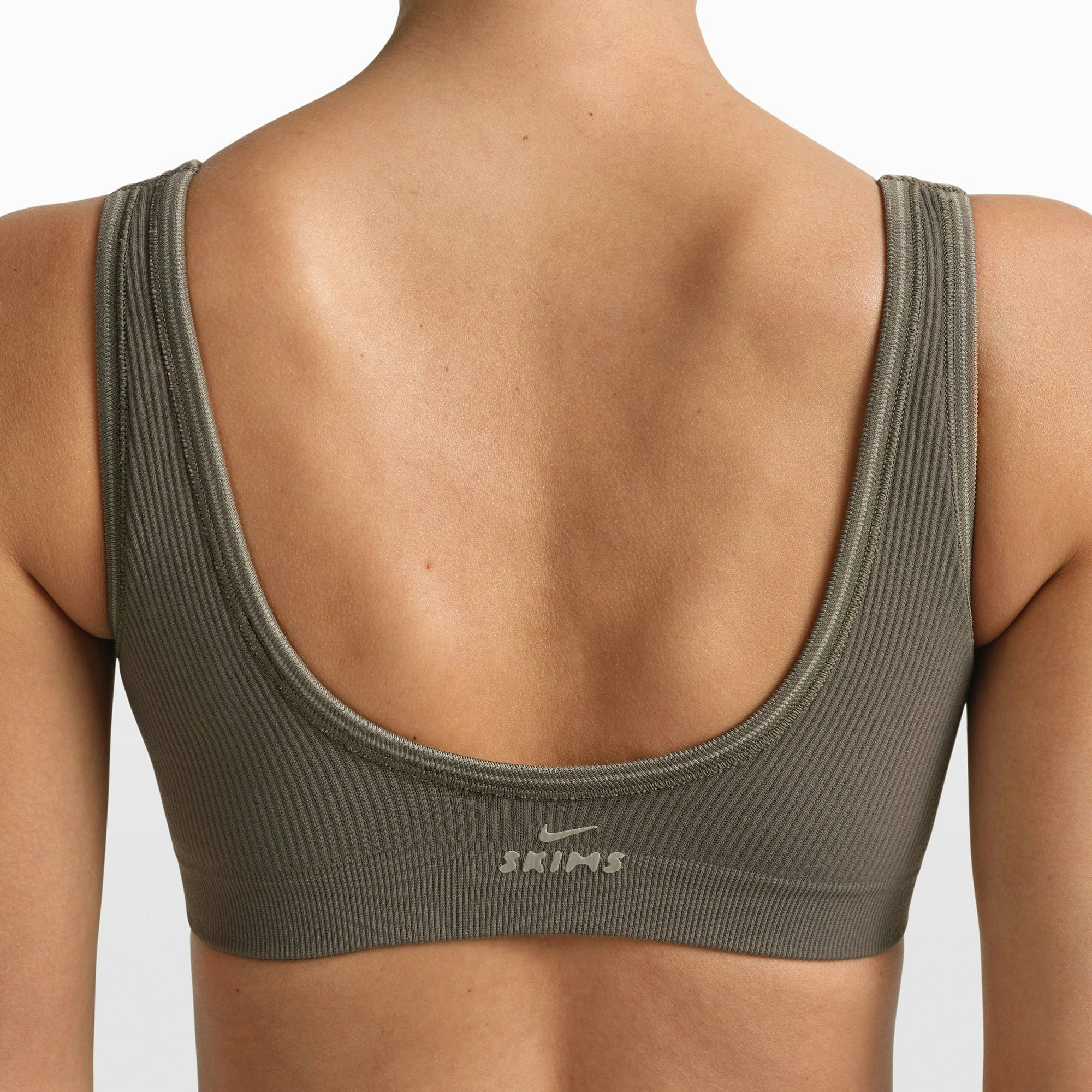 NikeSKIMS RIBBED SEAMLESS MICRO SCOOP BRA | DUSTY OAKMOSS/DUNE ON A MODEL FRONT VIEW @ | FOCUS: 0.0, 1.0, 0.9