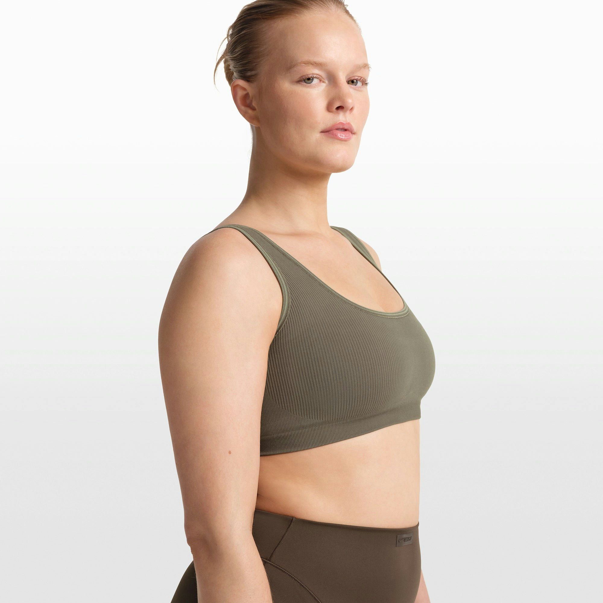 NikeSKIMS RIBBED SEAMLESS SCOOP BRA | DUSTY OAKMOSS ON A MODEL FRONT VIEW @ | FOCUS: 0.0, 1.0, 0.9