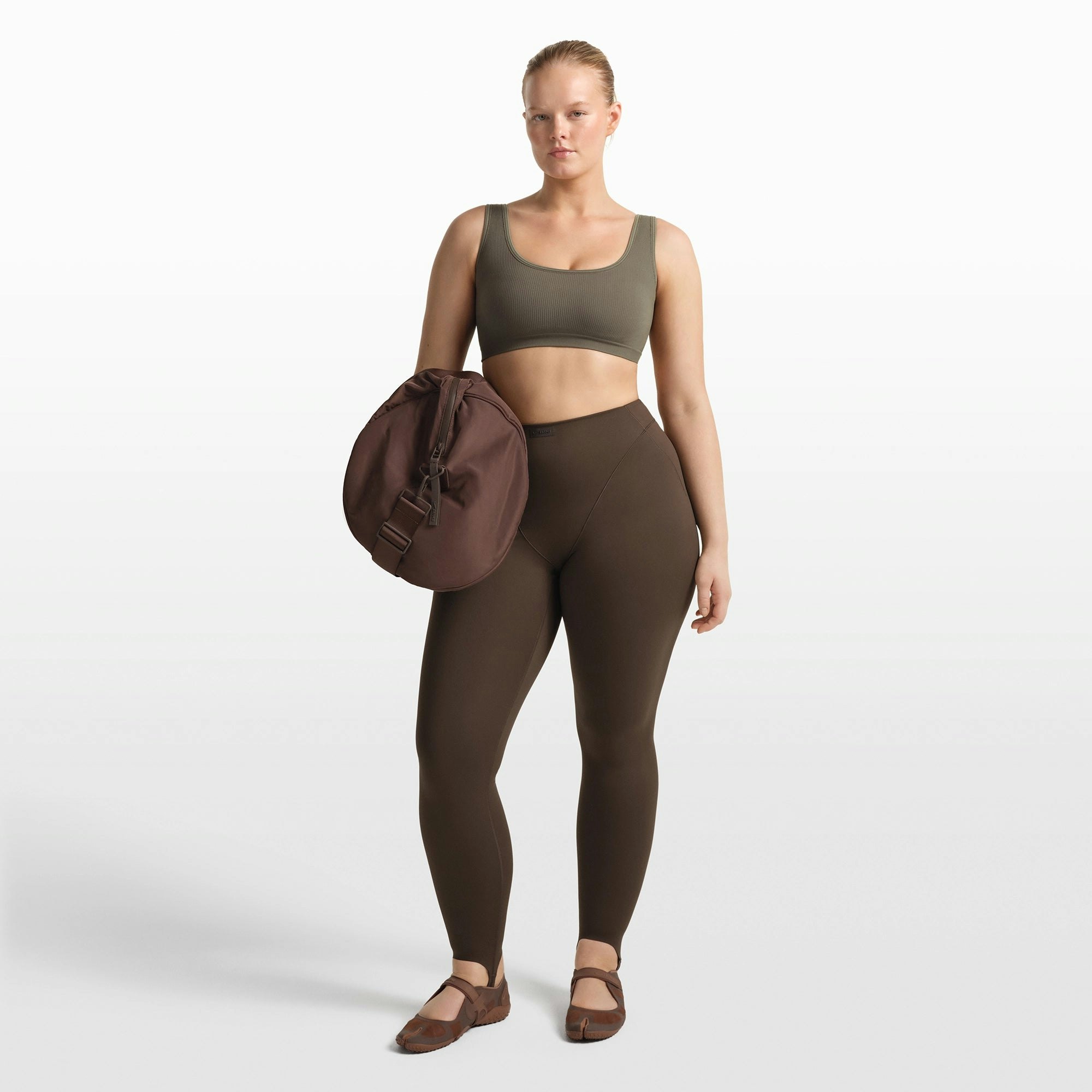 NikeSKIMS RIBBED SEAMLESS SCOOP BRA | DUSTY OAKMOSS/DUNE ON A MODEL FRONT VIEW @ | FOCUS: 0.0, 1.0, 0.9