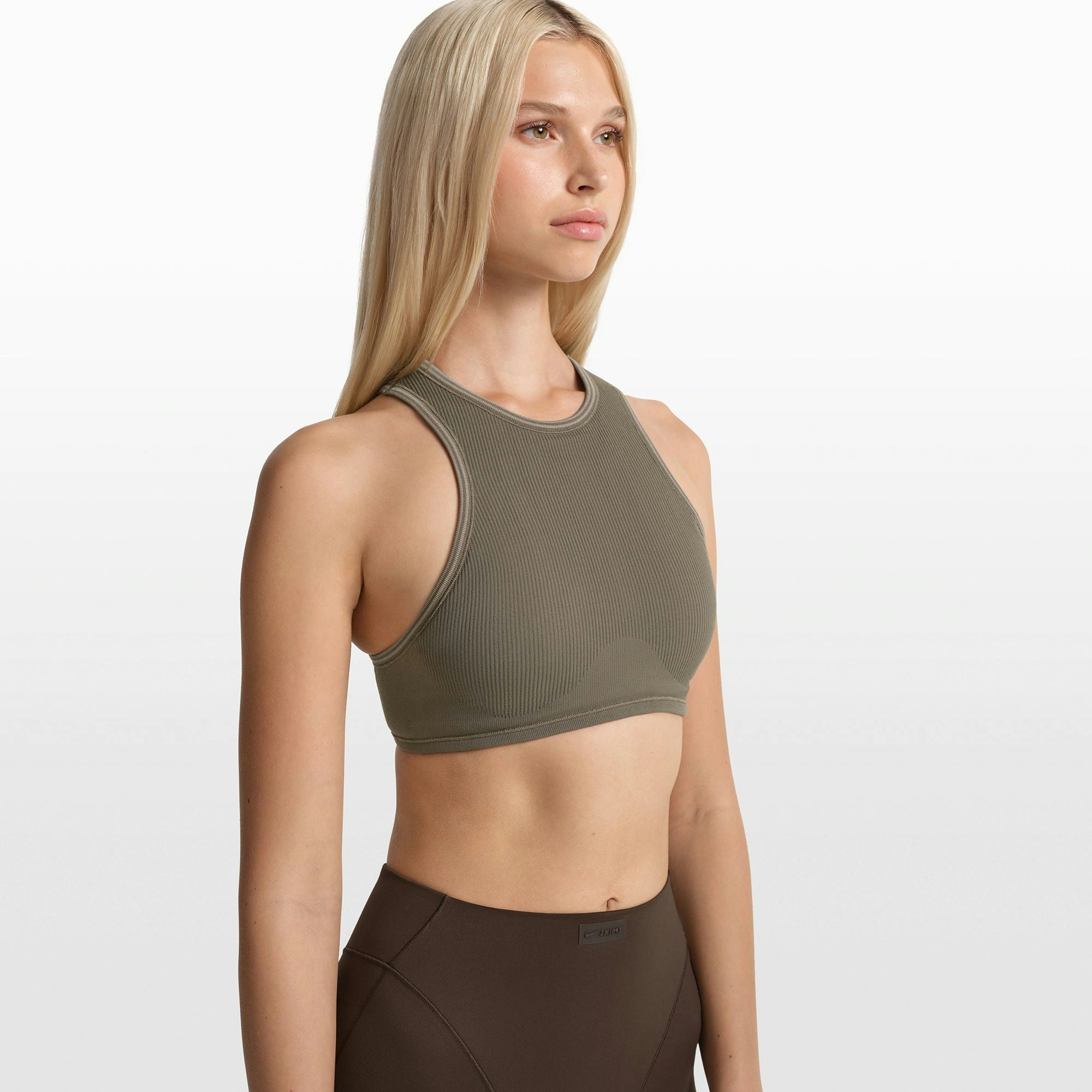NikeSKIMS RIBBED SEAMLESS RACER FRONT BRA | DUSTY OAKMOSS/DUNE ON A MODEL FRONT VIEW @ | FOCUS: 0.0, 1.0, 0.9