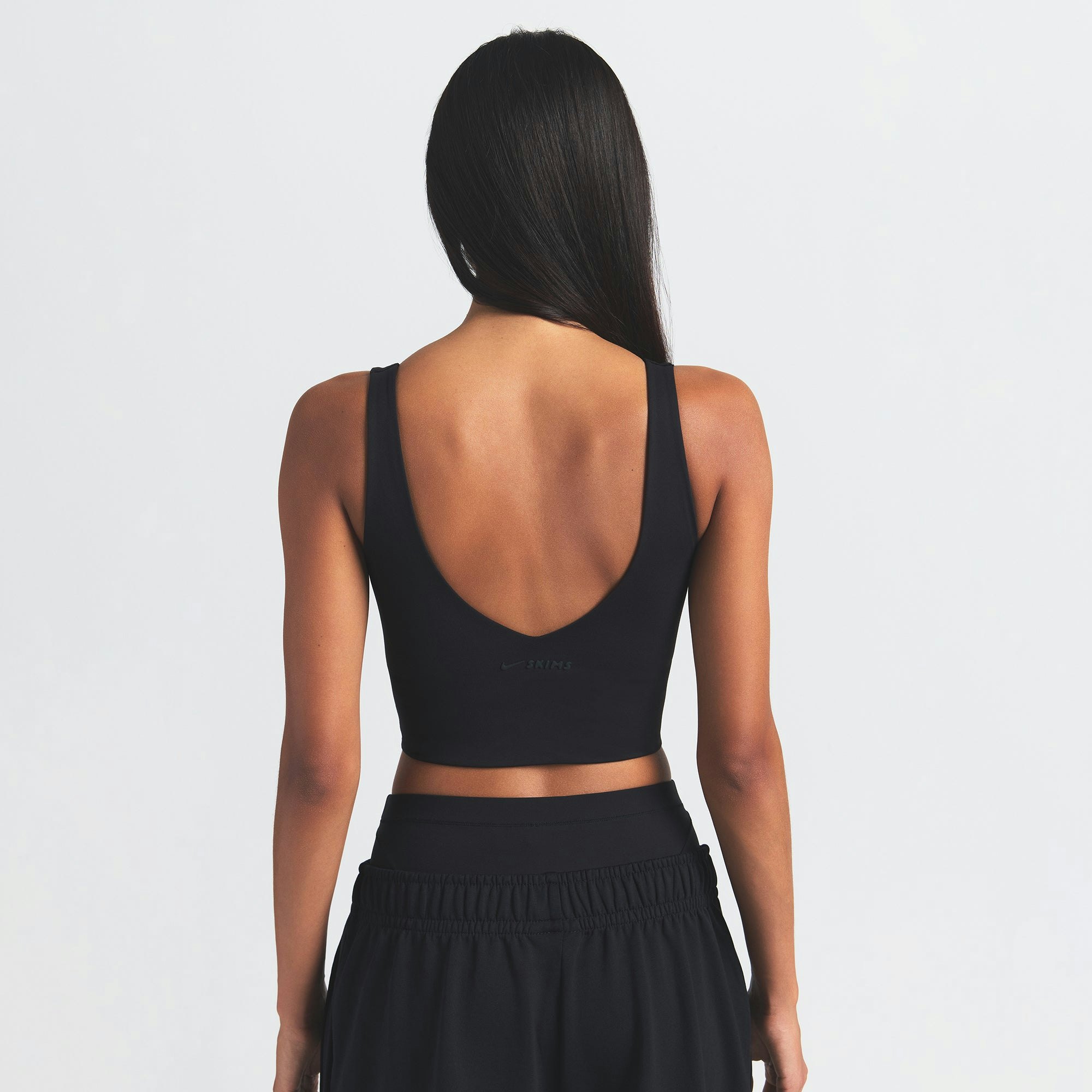 NikeSKIMS MATTE V-NECK BRA TOP | OBSIDIAN ON A MODEL BACK VIEW