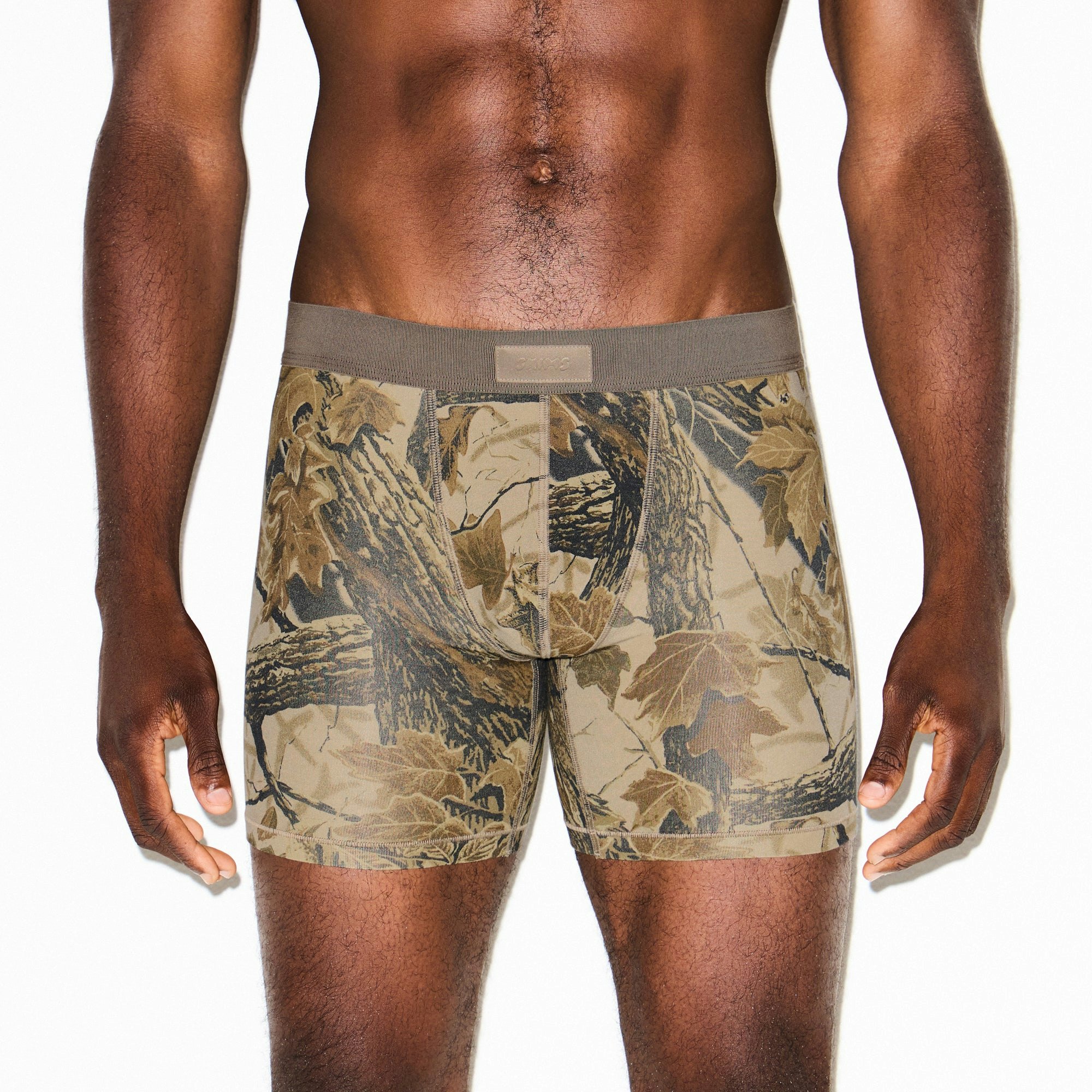 SKIMS COTTON MENS 5" BOXER BRIEF | REALTREE CAMO PRINT ON A MODEL SIDE VIEW @ | FOCUS: 0.9, 0.1, 0.7