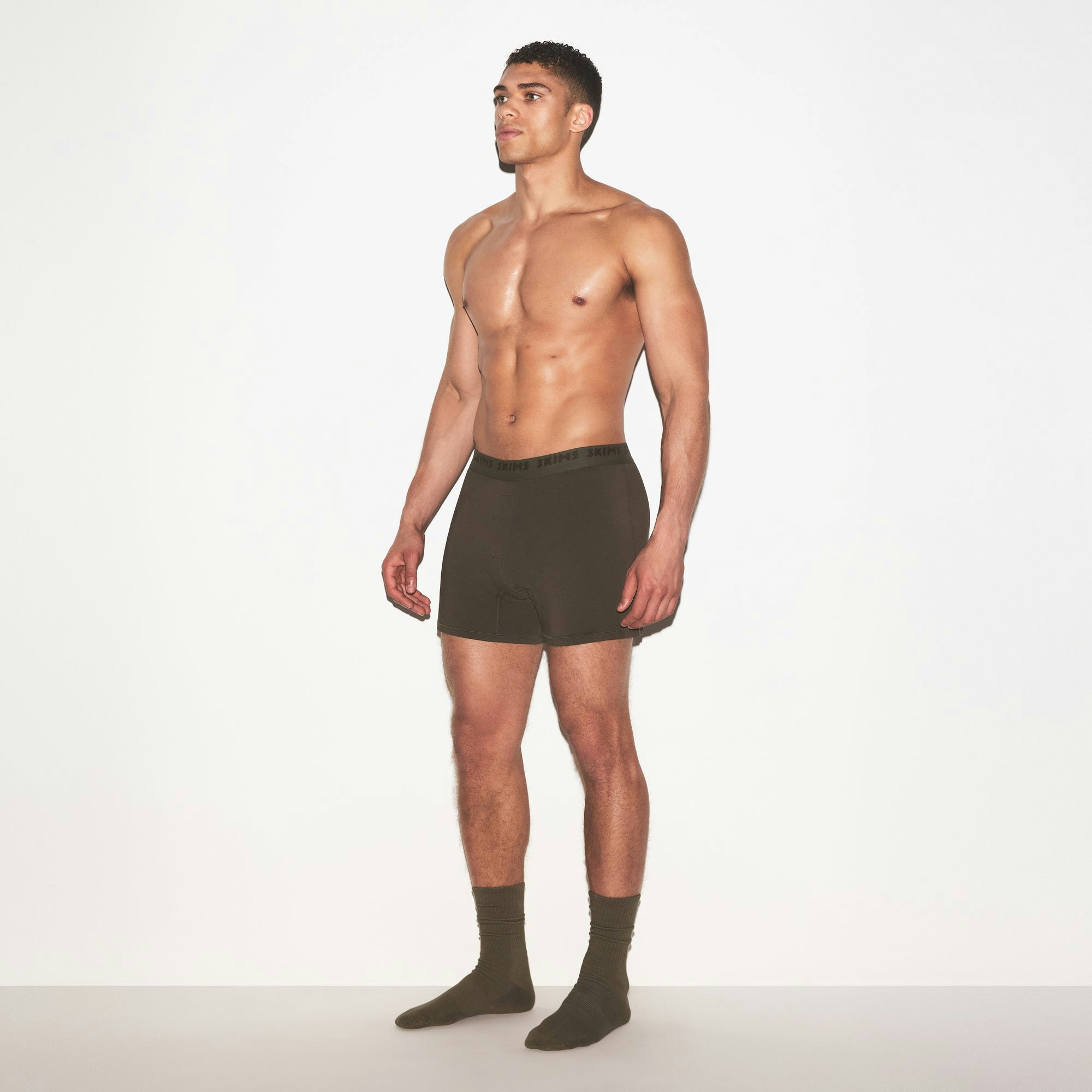 SKIMS STRETCH MENS KNIT BOXER | LODEN ON A MODEL FRONT VIEW @ | FOCUS: 0.0, 1.0, 0.9