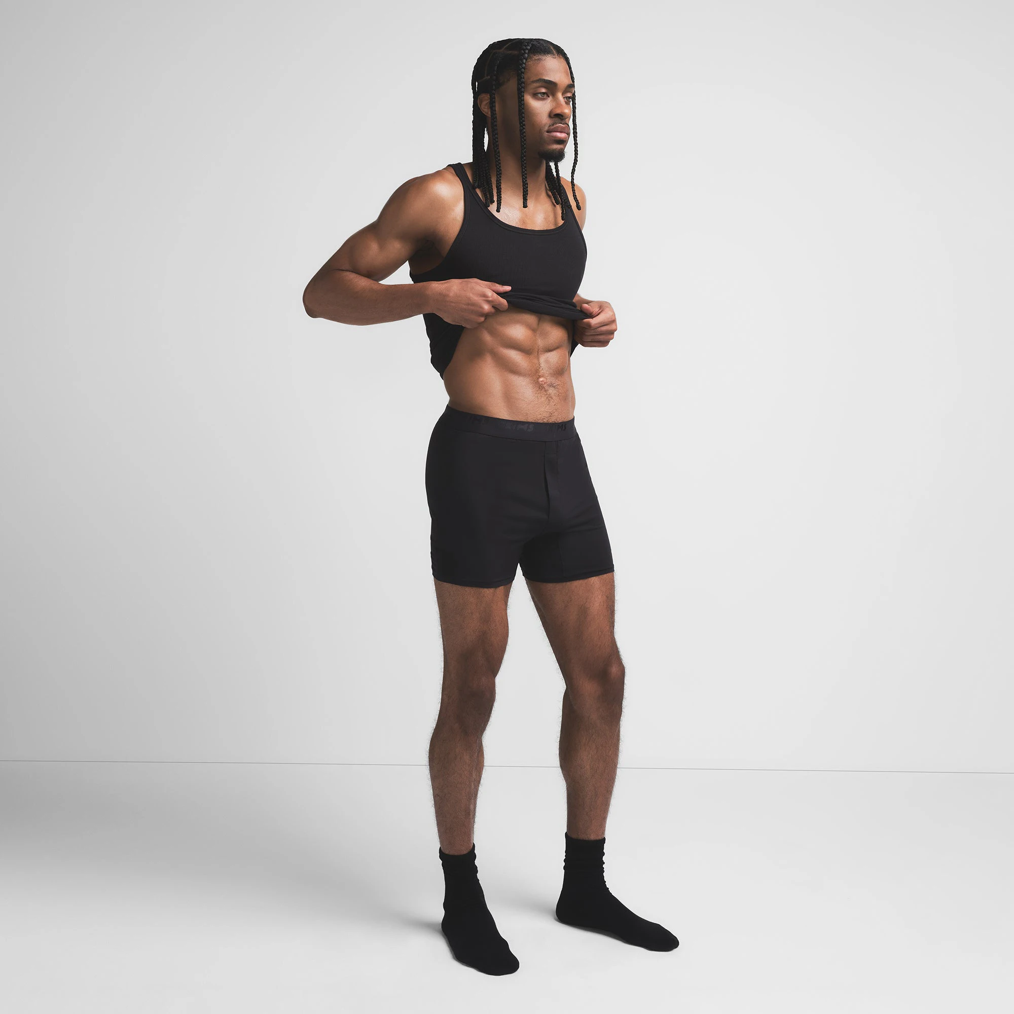 SKIMS STRETCH MENS KNIT BOXER | OBSIDIAN ON A MODEL SIDE VIEW @ | FOCUS: 0.9, 0.1, 0.7