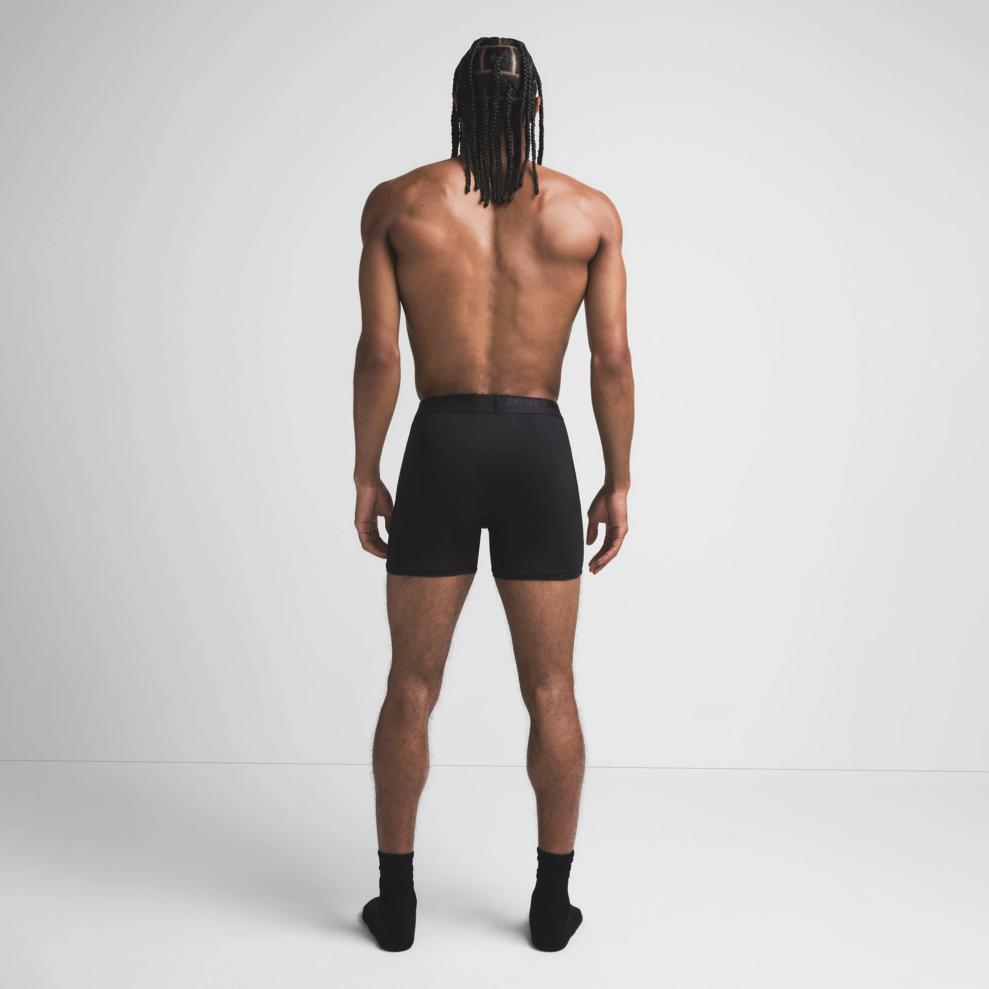 SKIMS STRETCH MENS KNIT BOXER | OBSIDIAN ON A MODEL BACK VIEW @ | FOCUS: 0.9, 0.1, 0.7