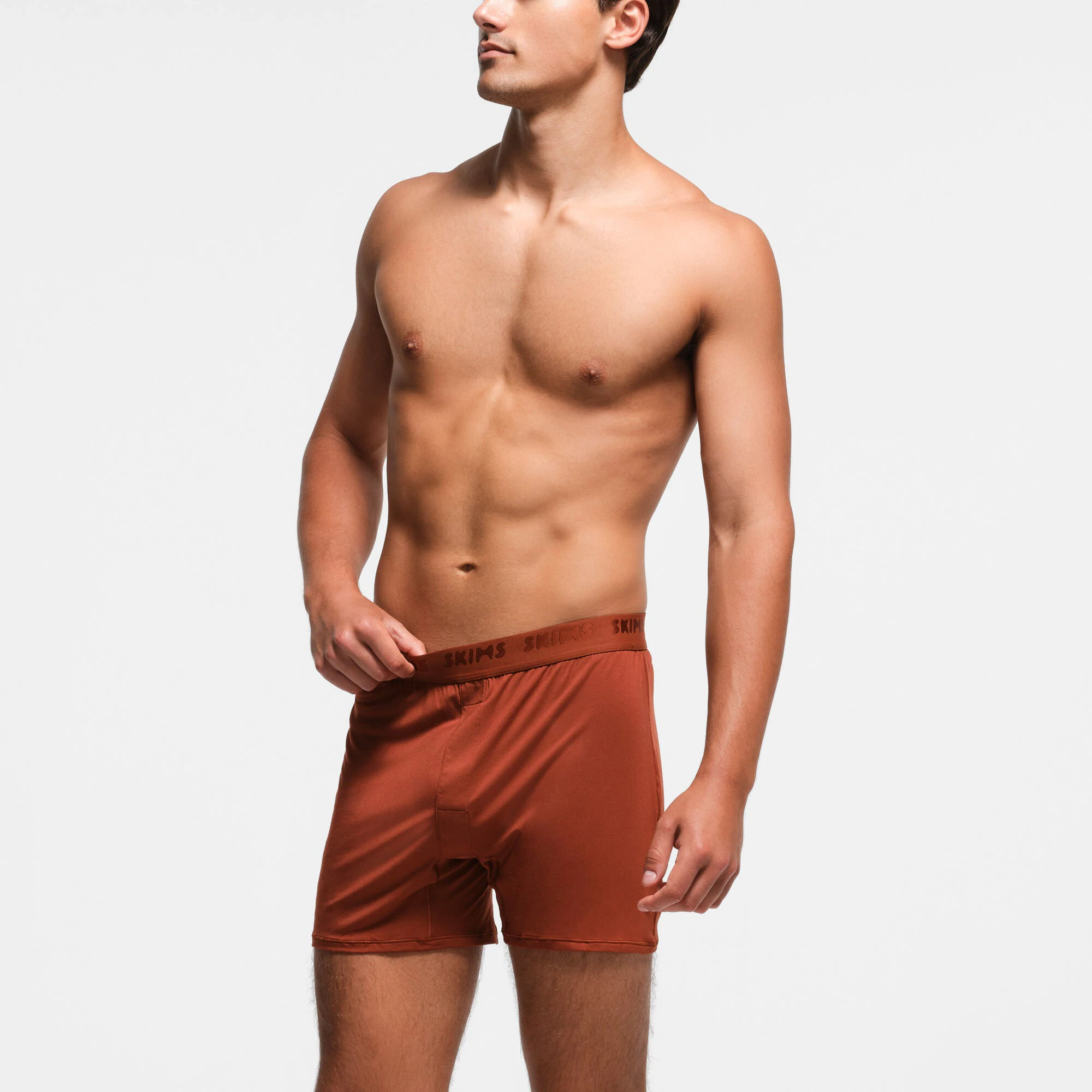SKIMS STRETCH MENS KNIT BOXER 3-PACK | RUST MULTI ON A MODEL SIDE VIEW