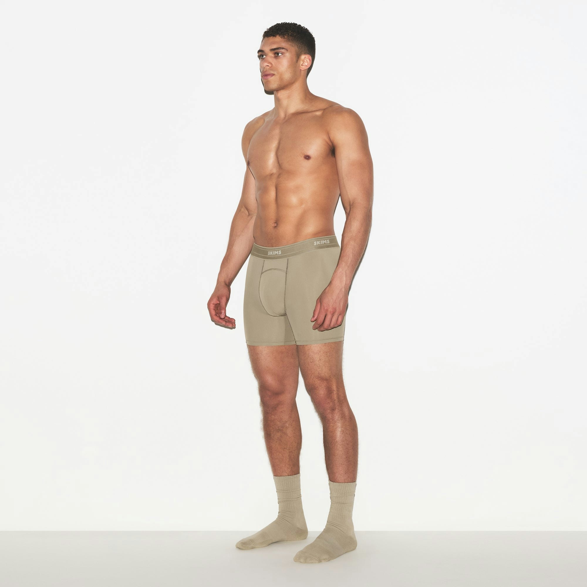 SKIMS SPORT MENS 5 INCH BOXER BRIEF 3-PACK | DUNE MULTI ON A MODEL FRONT VIEW | FOCUS: 0.0, 1.0, 0.9