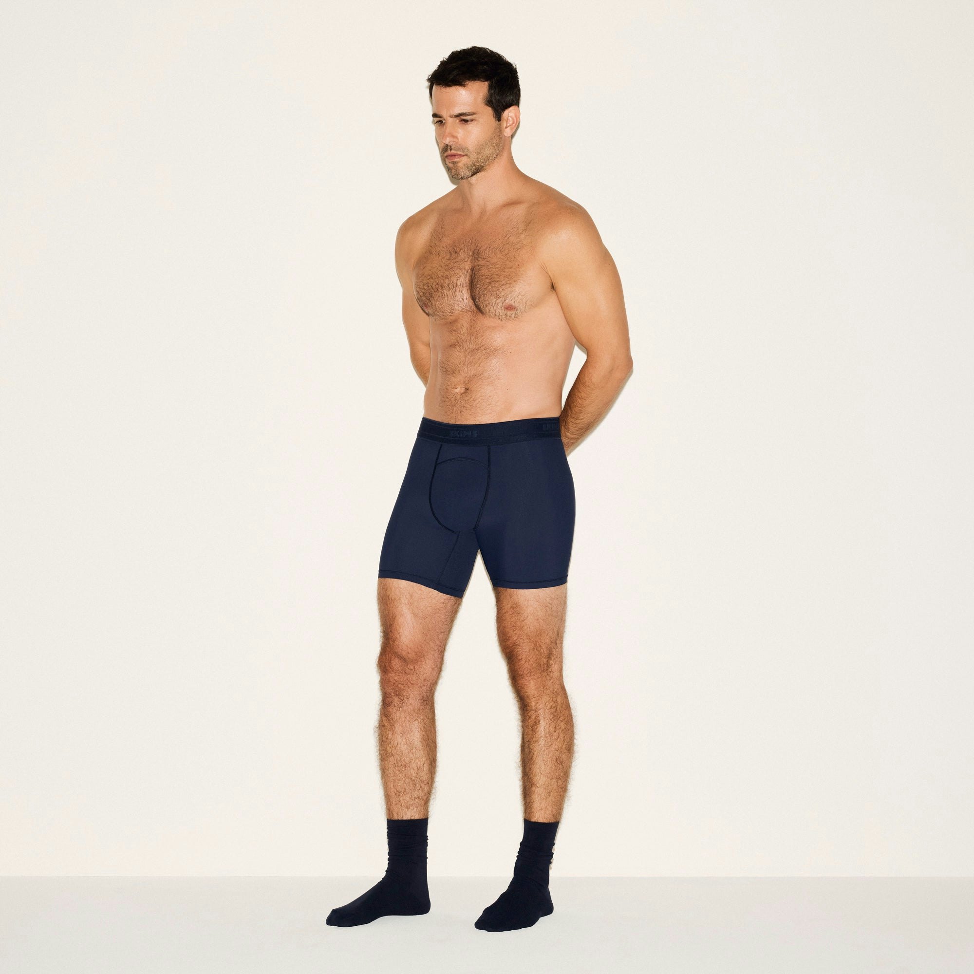SKIMS SPORT MENS 5 INCH BOXER BRIEF 3-PACK | NAVY SMOKE MULTI ON A MODEL SIDE VIEW | FOCUS: 0.0, 1.0, 0.9