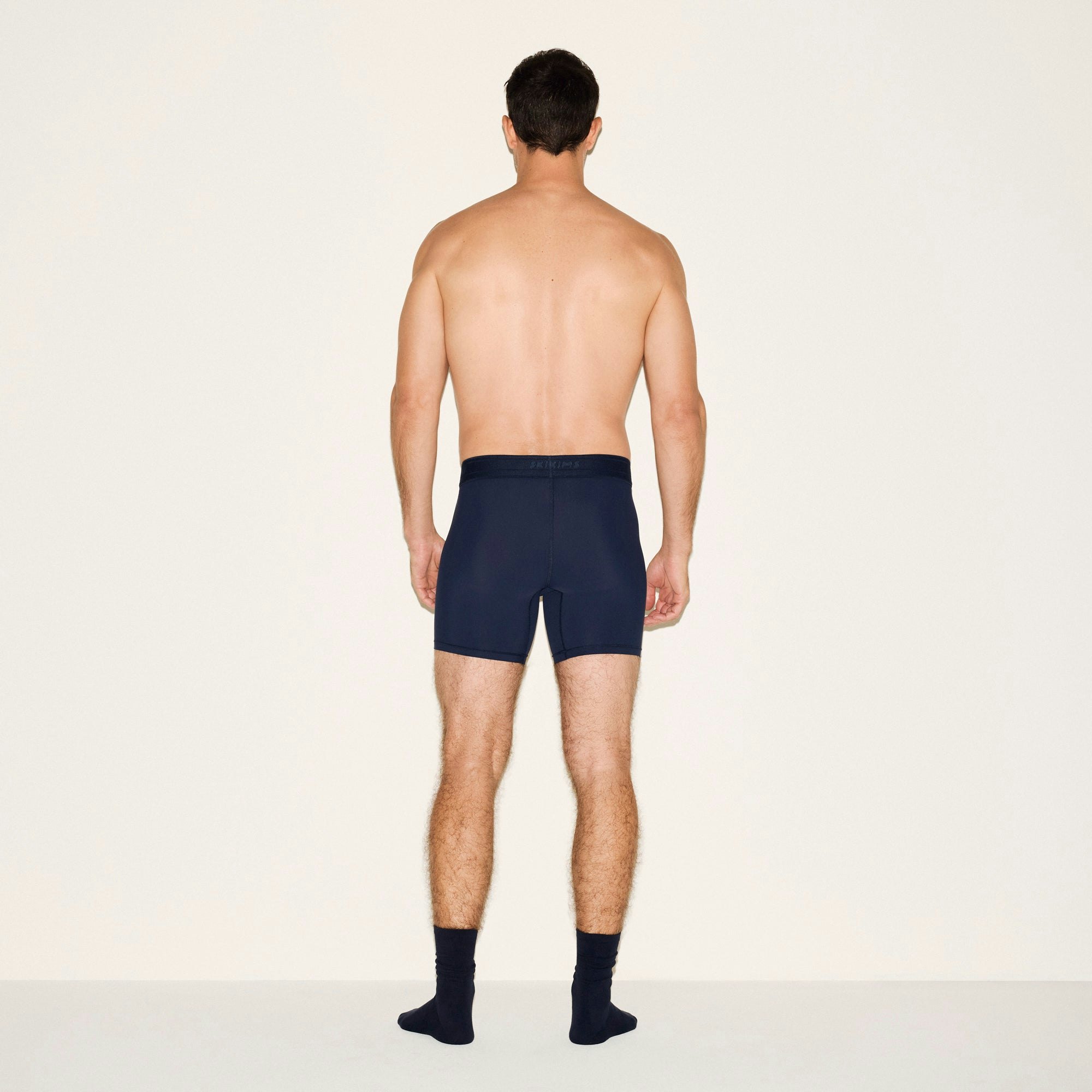 SKIMS SPORT MENS 5 INCH BOXER BRIEF 3-PACK | NAVY SMOKE MULTI ON A MODEL SIDE VIEW | FOCUS: 0.0, 1.0, 0.9