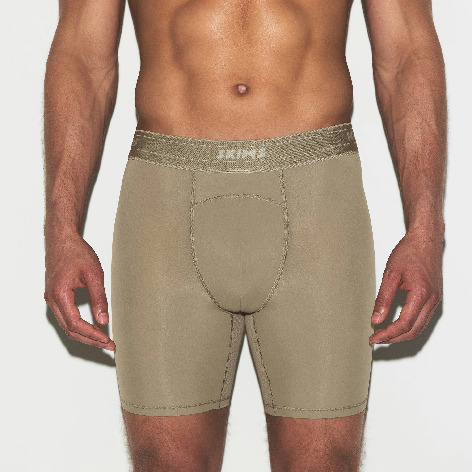 SKIMS SPORT MENS 7 INCH 3-PACK | DUNE MULTI ON A MODEL SIDE VIEW | FOCUS: 0.0, 1.0, 0.9