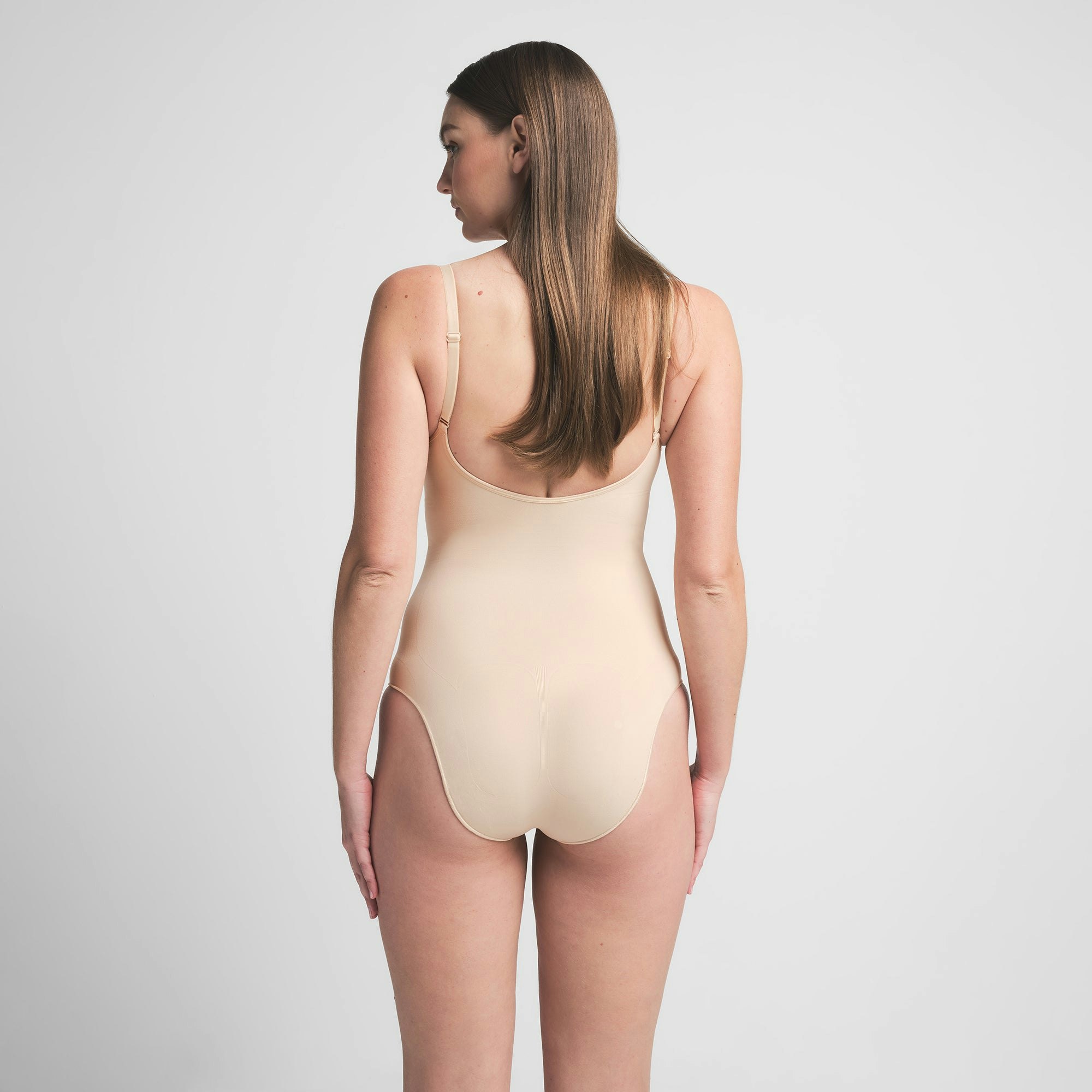 SEAMLESS SCULPT BRIEF BODYSUIT | SAND ON A MODEL BACK VIEW | FOCUS: 0.0, 1.0, 0.9