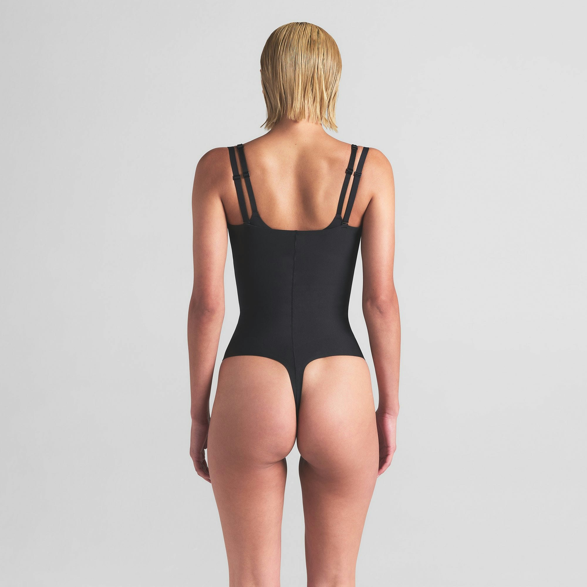 SKIMS BODY CORE SCULPT OPEN BUST THONG BODYSUIT | ONYX ON A MODEL BACK VIEW | FOCUS: 0.0, 1.0, 0.9
