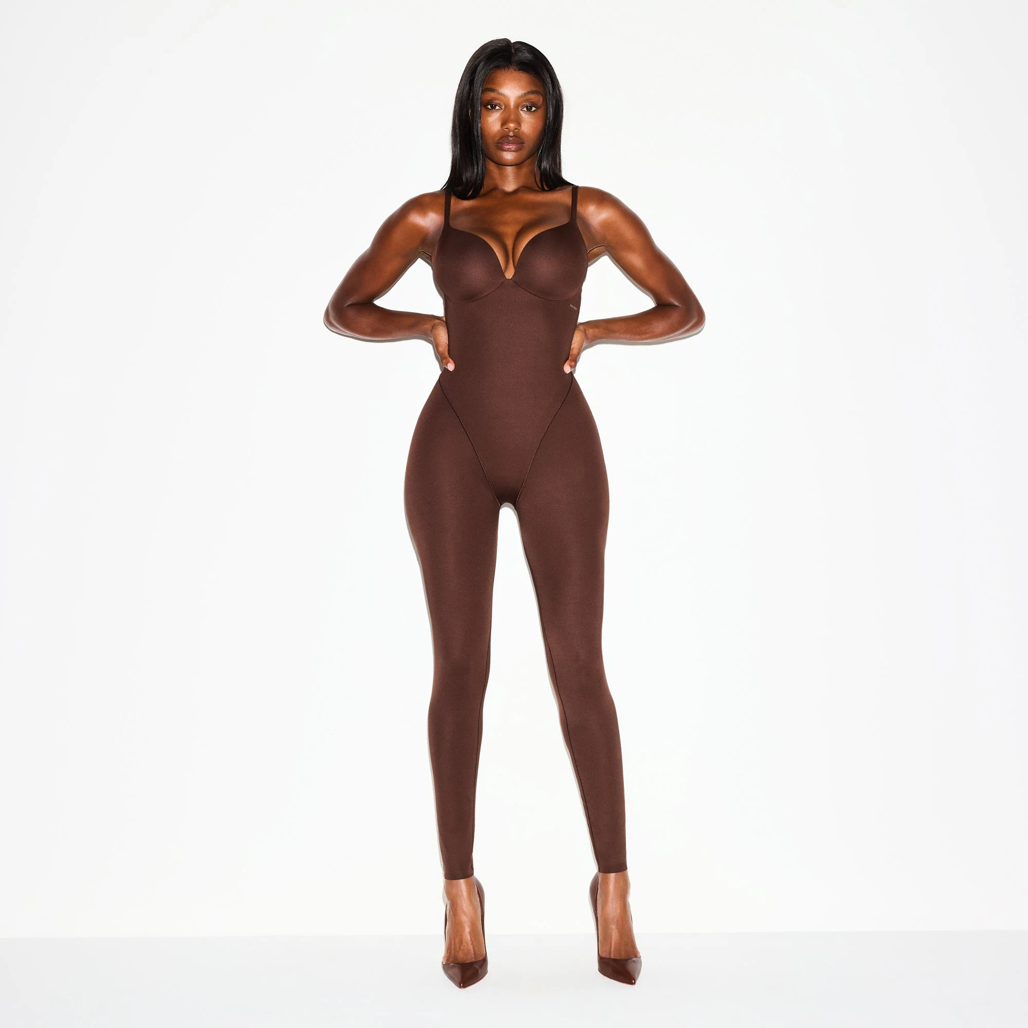 SKIMS ULTIMATE BODY BUTT AND HIP ENHANCING CATSUIT | COCOA ON A MODEL FRONT VIEW @ | FOCUS: 0.0, 1.0, 0.9
