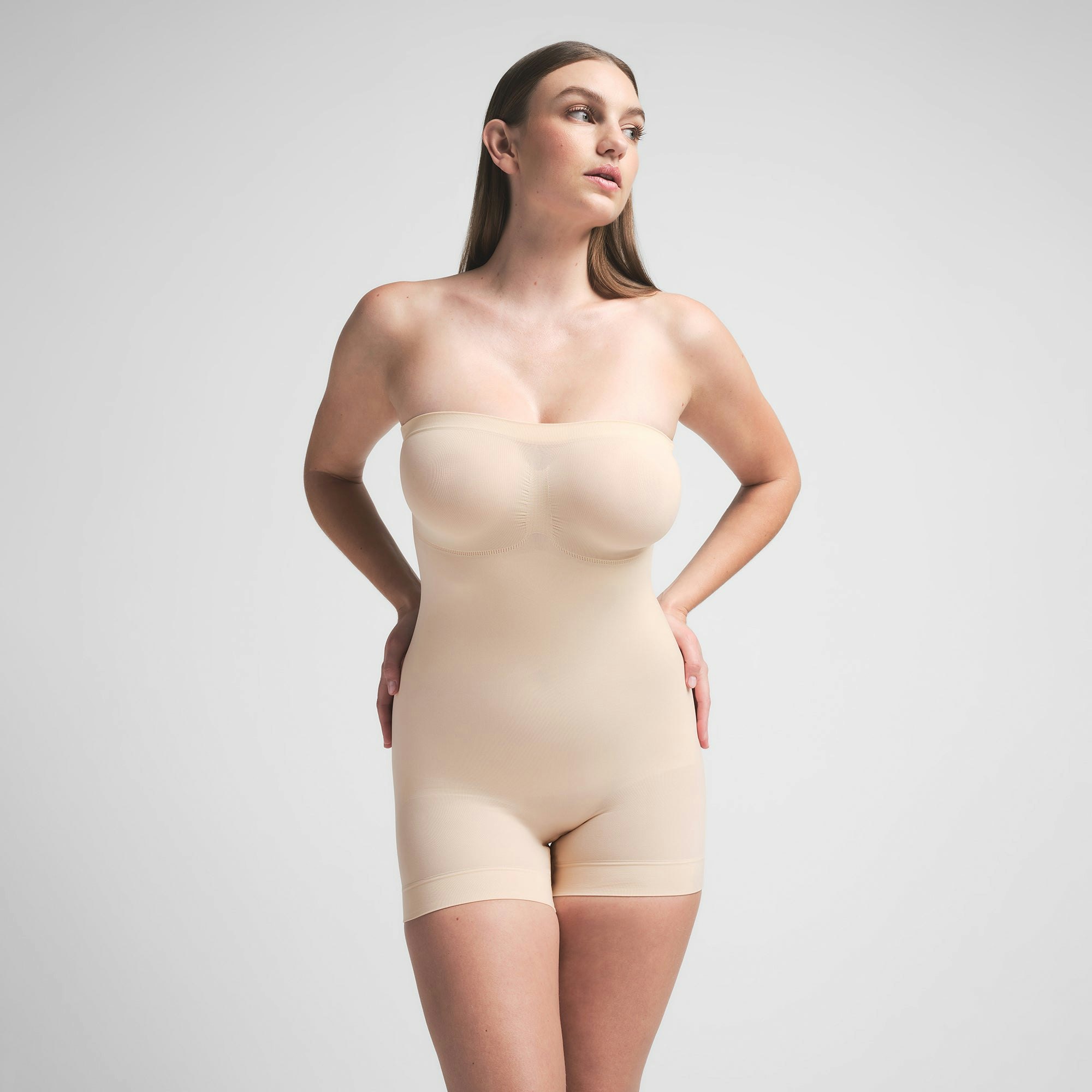 SEAMLESS SCULPT STRAPLESS SHORTIE BODYSUIT | SAND ON A MODEL FRONT VIEW | FOCUS: 0.0, 1.0, 0.9