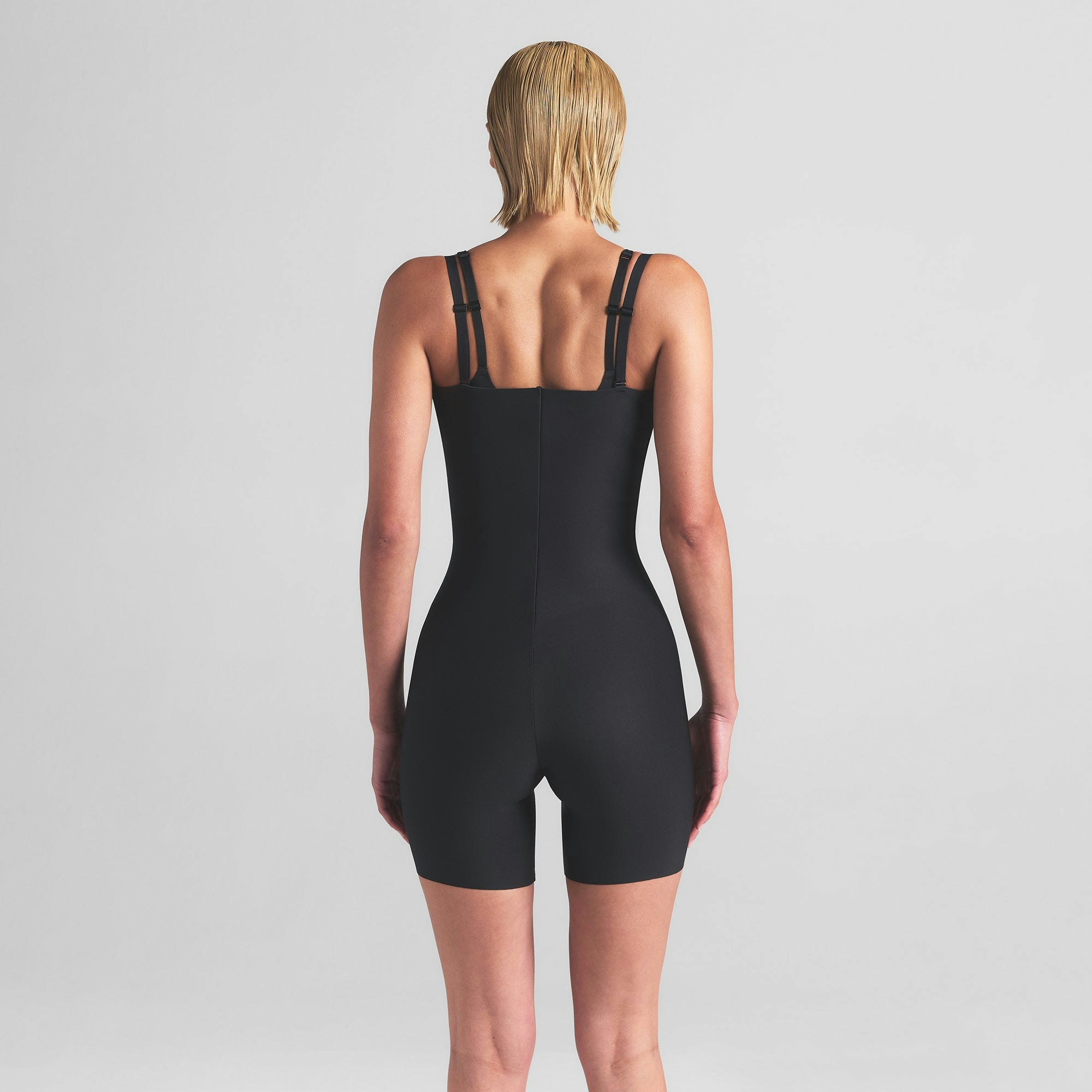 SKIMS BODY CORE SCULPT OPEN BUST MID THIGH BODYSUIT | ONYX ON A MODEL BACK VIEW | FOCUS: 0.0, 1.0, 0.9