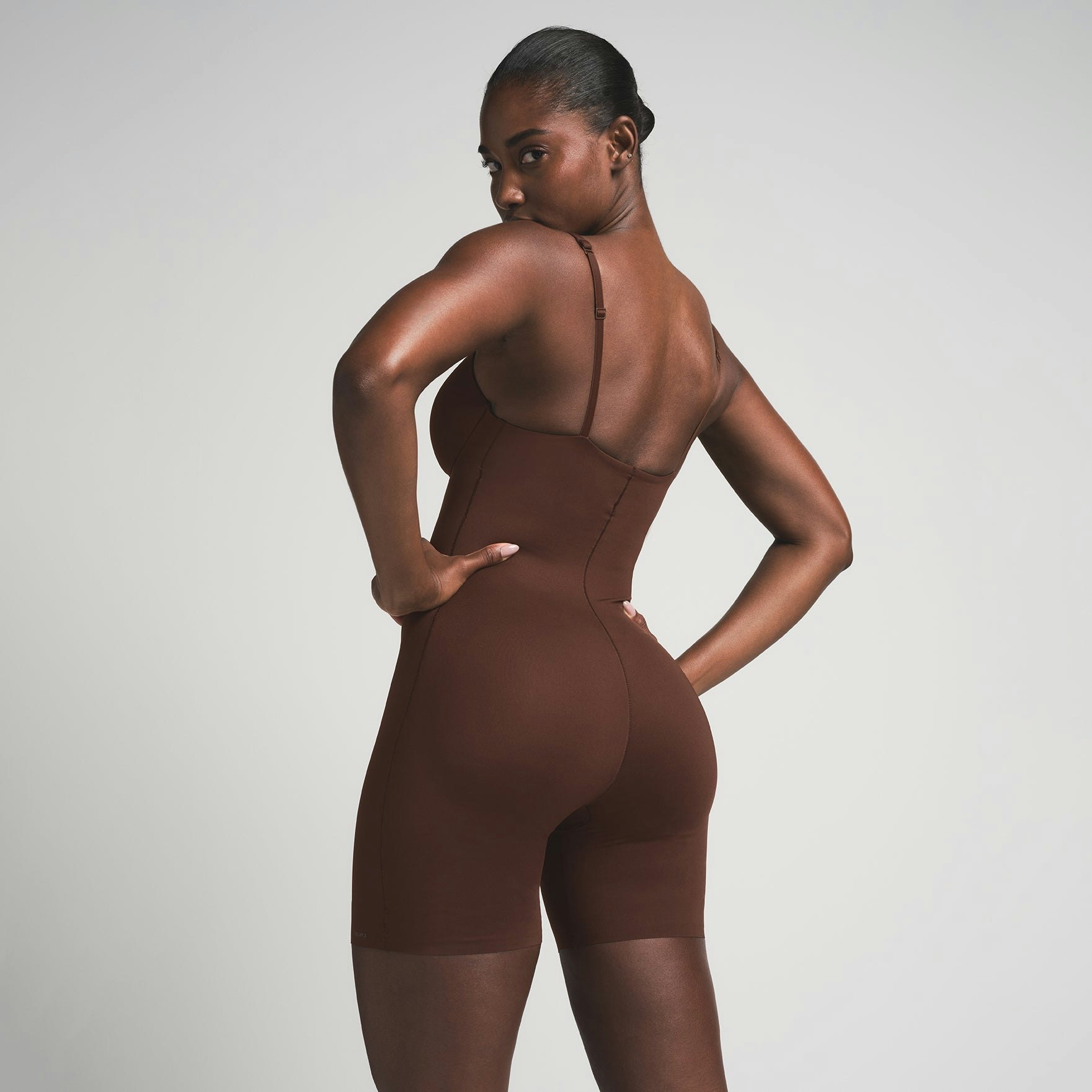 SKIMS ULTIMATE BODY PUSH-UP BUTT ENHANCING PADDED MID THIGH BODYSUIT | COCOA  ON A MODEL BACK VIEW | FOCUS: 0.0, 1.0, 0.9