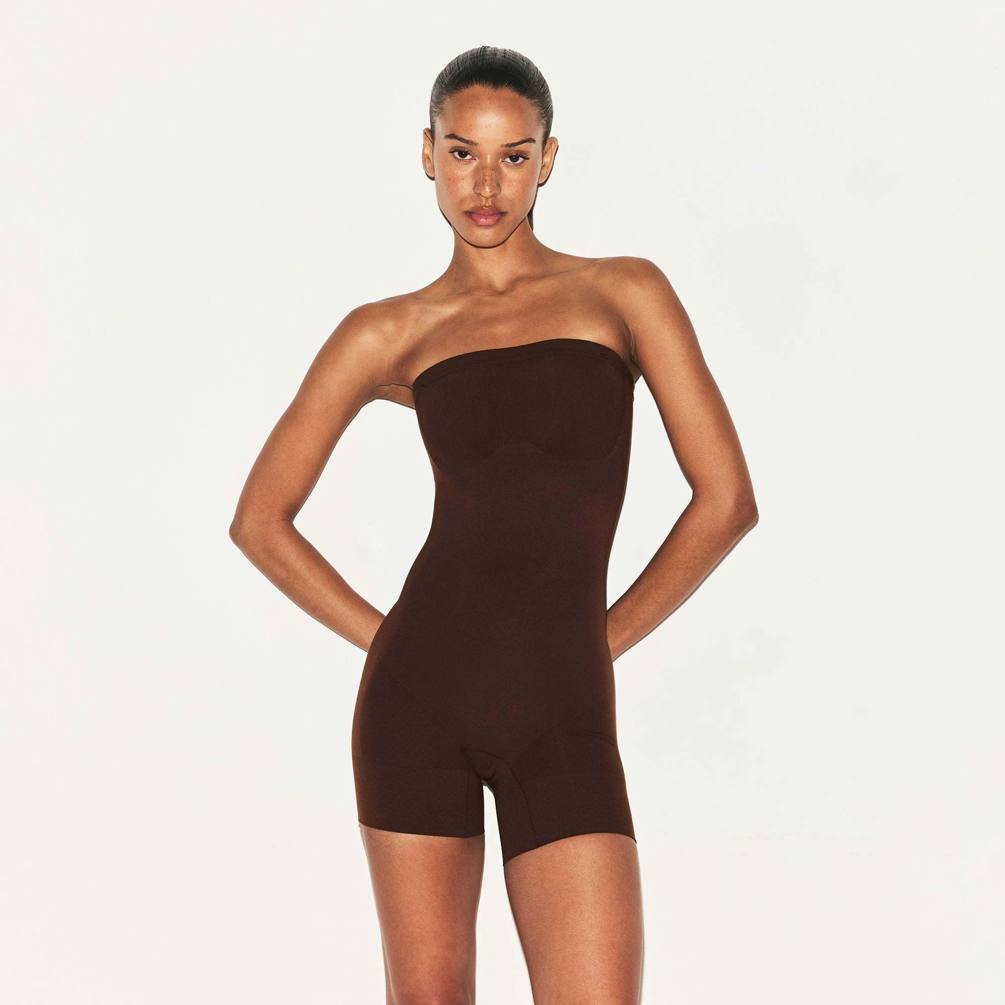 SHEER SEAMLESS STRAPLESS SHORTIE BODYSUIT | COCOA ON A MODEL FRONT VIEW