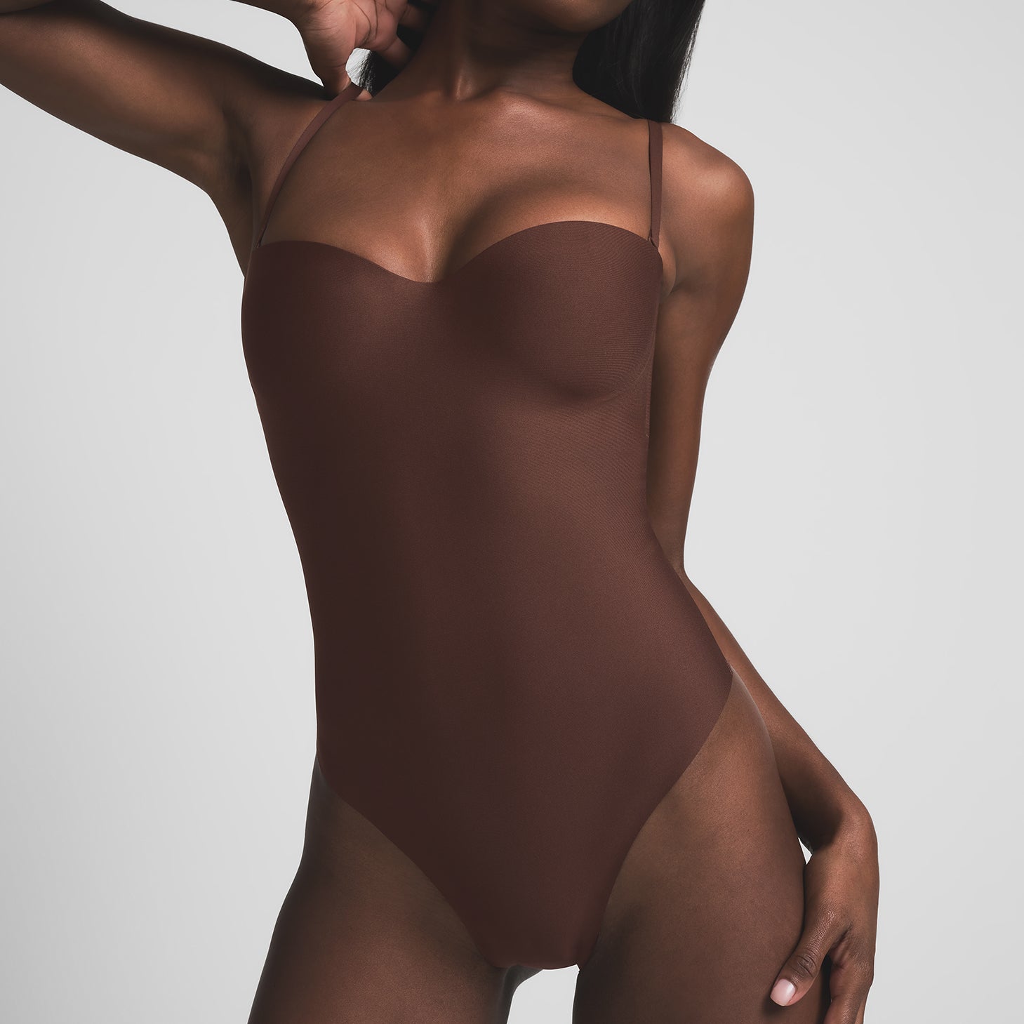 SKIMS BODY UNDERWIRE THONG BODYSUIT | COCOA ON A MODEL FRONT VIEW | FOCUS: 0.9, 0.1, 0.7